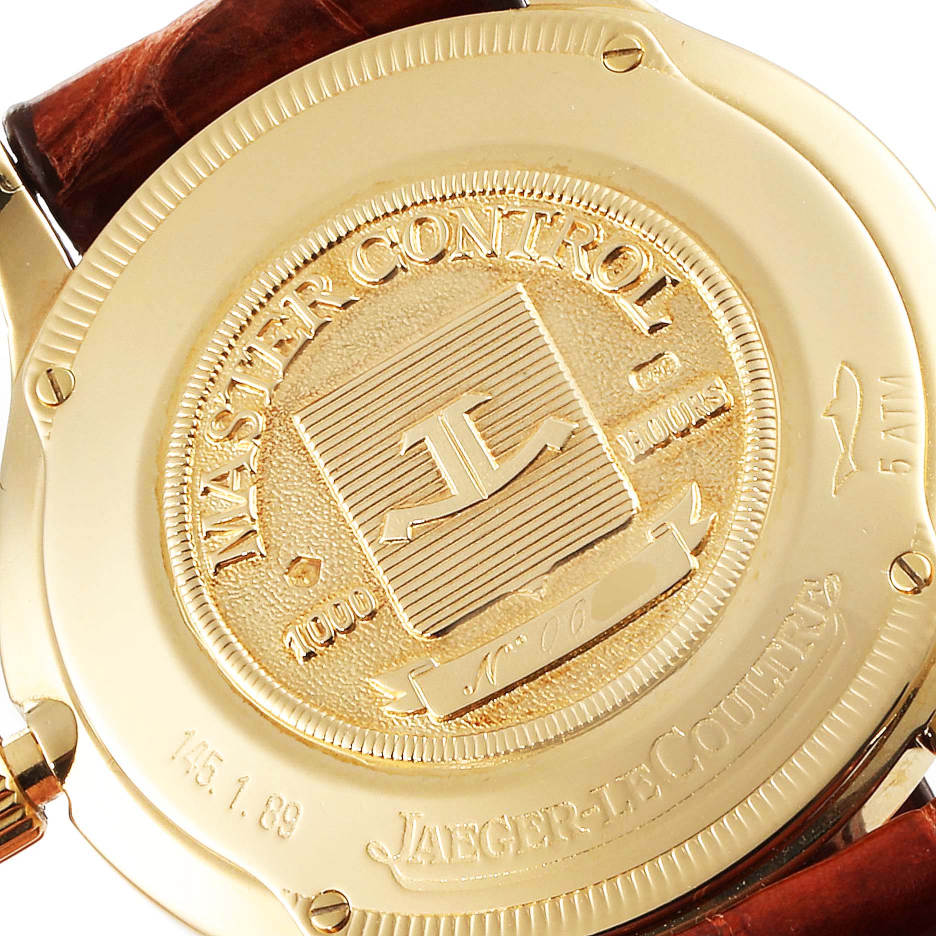 This image shows the back of a Jaeger-LeCoultre Master Control watch, highlighting its engraved gold casing and branding.