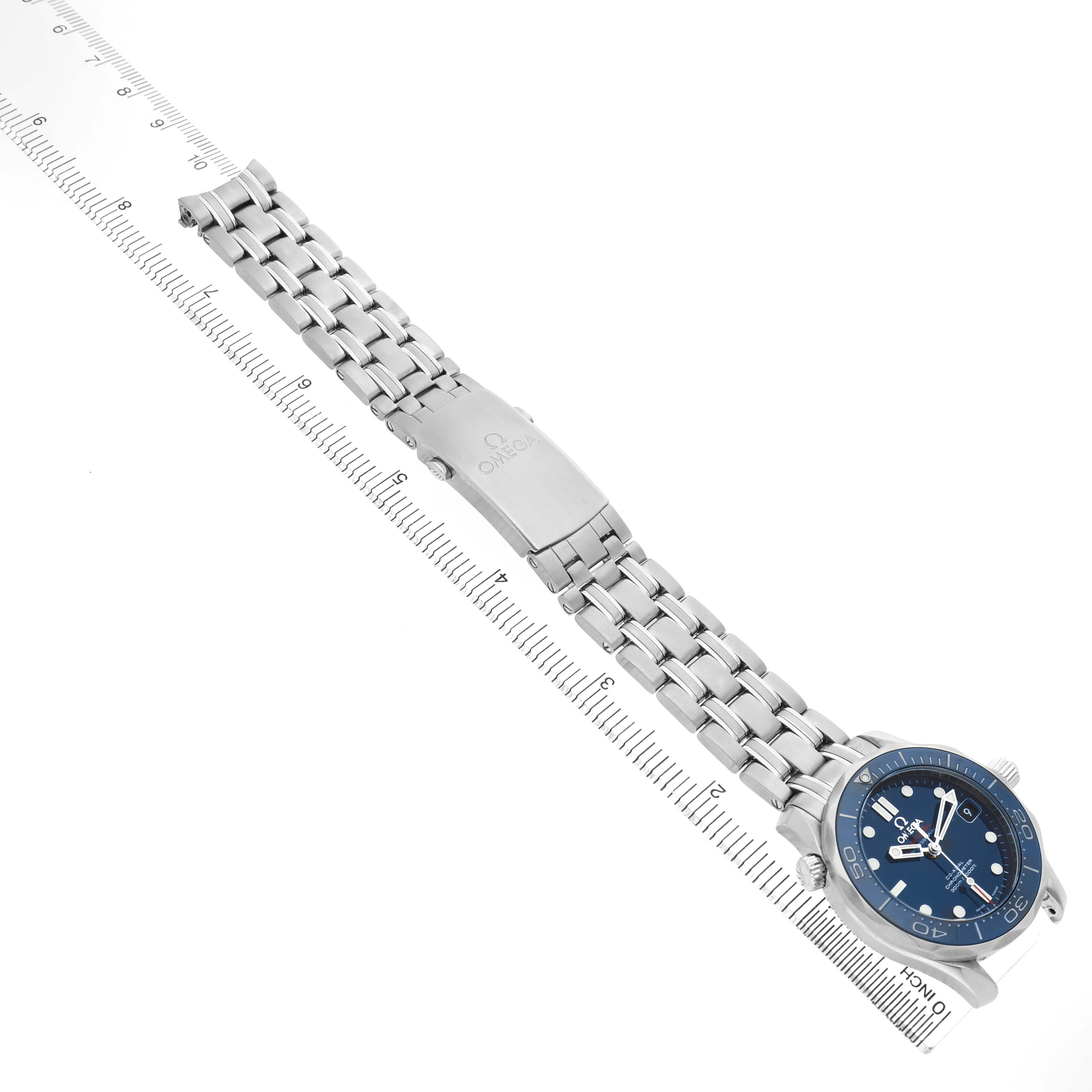 The Omega Seamaster 212.30.36.20.03.001 Men's Stainless Steel Blue Dial watch is shown at an angle displaying its face, bracelet, and clasp, with a ruler alongside for scale.
