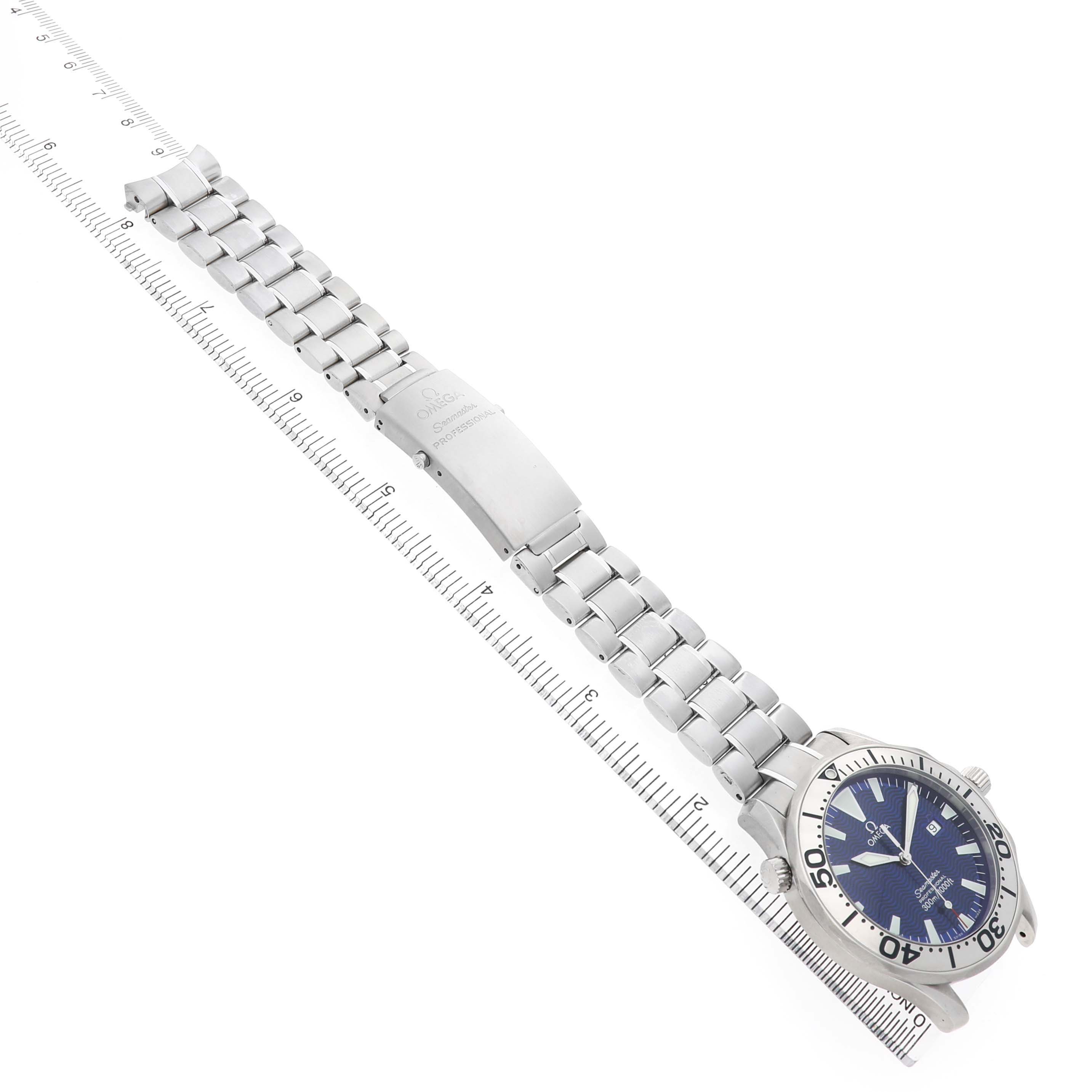 The Omega Seamaster 2265.80.00 Men's Stainless Steel Blue Dial watch is shown flat, highlighting the face, bezel, bracelet, and clasp alongside a ruler.