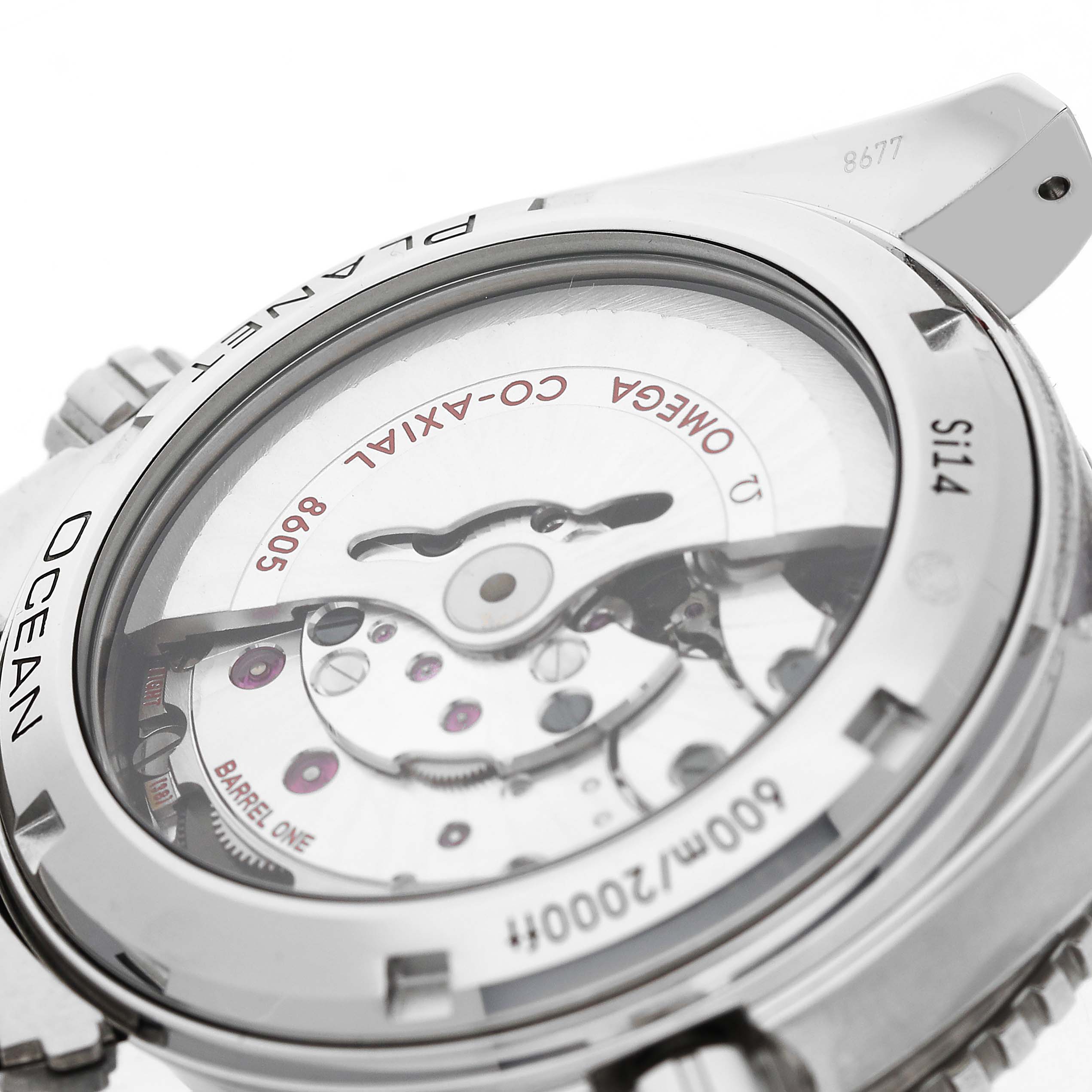The image shows the back view of the Omega Planet Ocean 232.30.44.22.01.002 Men's Stainless Steel Black Dial watch, highlighting its transparent case and inner mechanism.