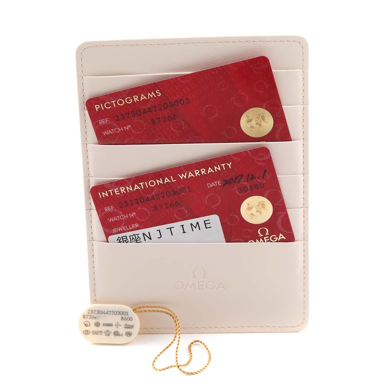 The image shows Omega Planet Ocean 232.30.44.22.03.001 Men
s Stainless Steel Blue Dial 232.30.44.22.03.001 Men
s Stainless Steel Blue Dial
s warranty cards and a tag with model details against a beige cardholder.