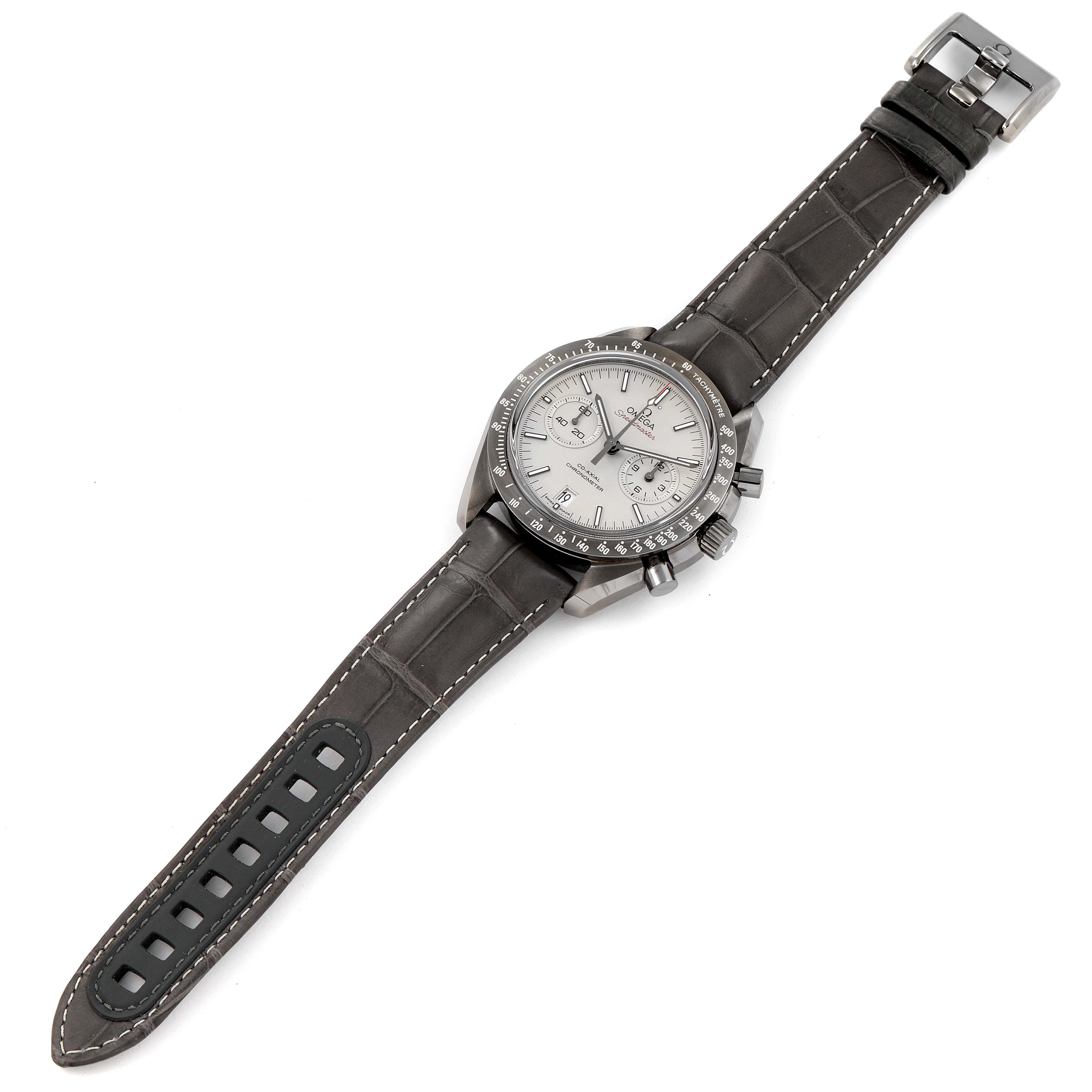 The Omega Speedmaster 311.93.44.51.99.001 Men's Ceramic Silver Dial 311.93.44.51.99.001 Men's Ceramic Silver Dial watch is shown from a top-down angle, displaying its face, bezel, chronograph buttons, and leather strap.