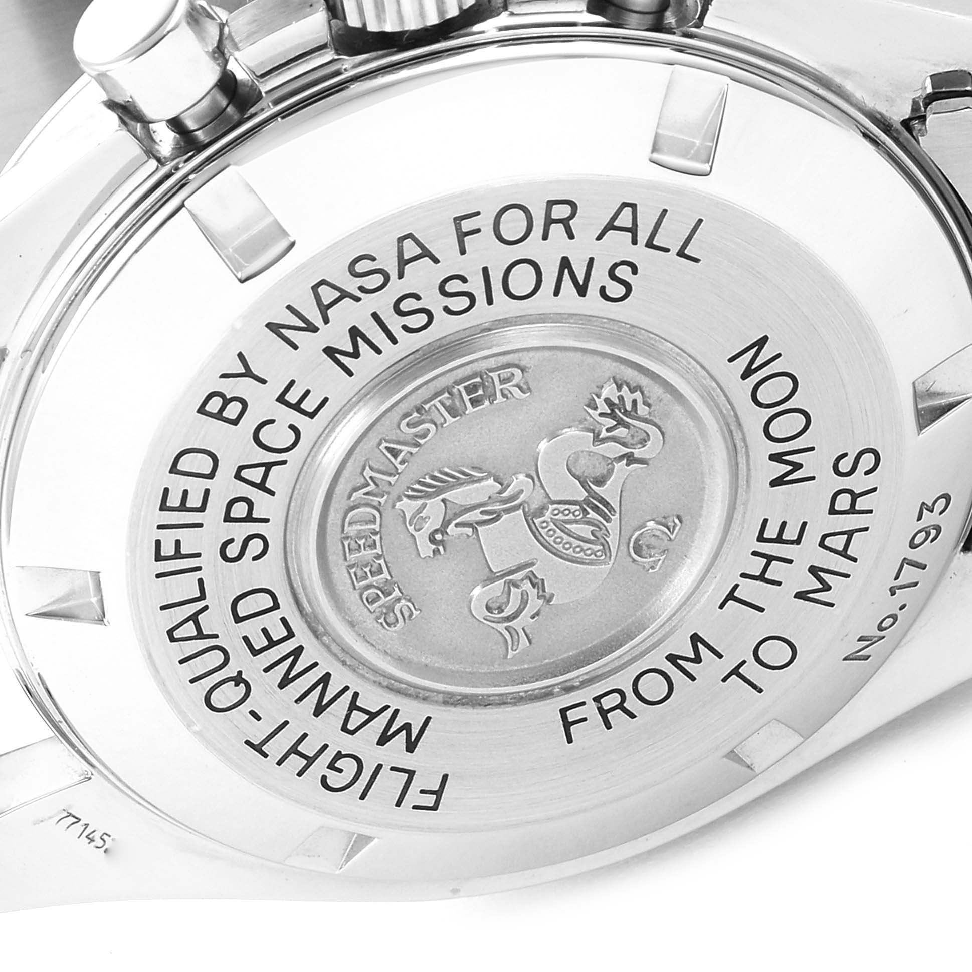 The image shows the back case of an Omega Speedmaster 3577.50.00 Men's Stainless Steel Black Dial 3577.50.00 Men's Stainless Steel Black Dial watch with engraved inscriptions and logo.