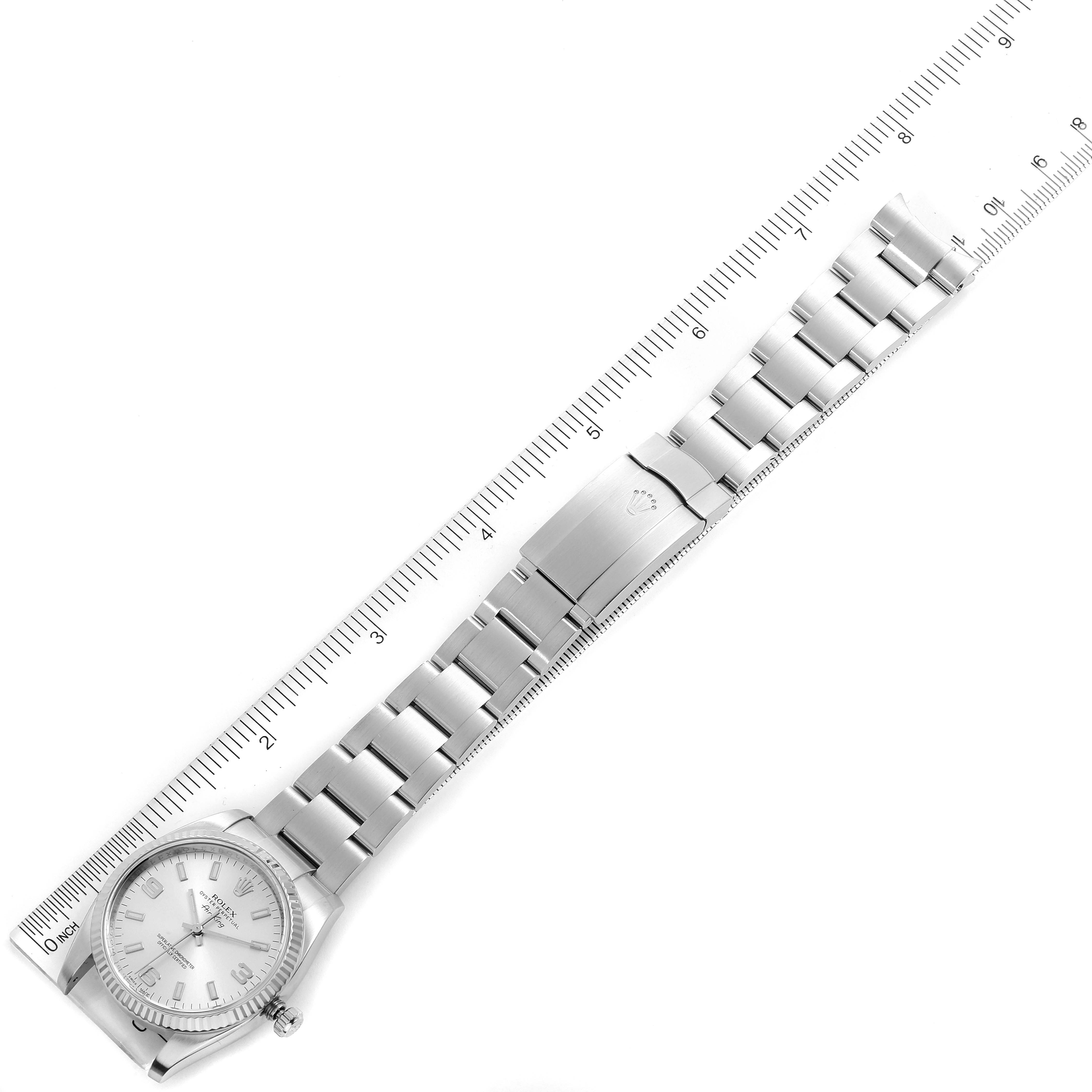 The image shows a top-down view of a Rolex Air-King 114234 Men's Stainless Steel Silver Dial 114234 Men's Stainless Steel Silver Dial watch, highlighting the face, bracelet, and clasp, with a ruler for scale.