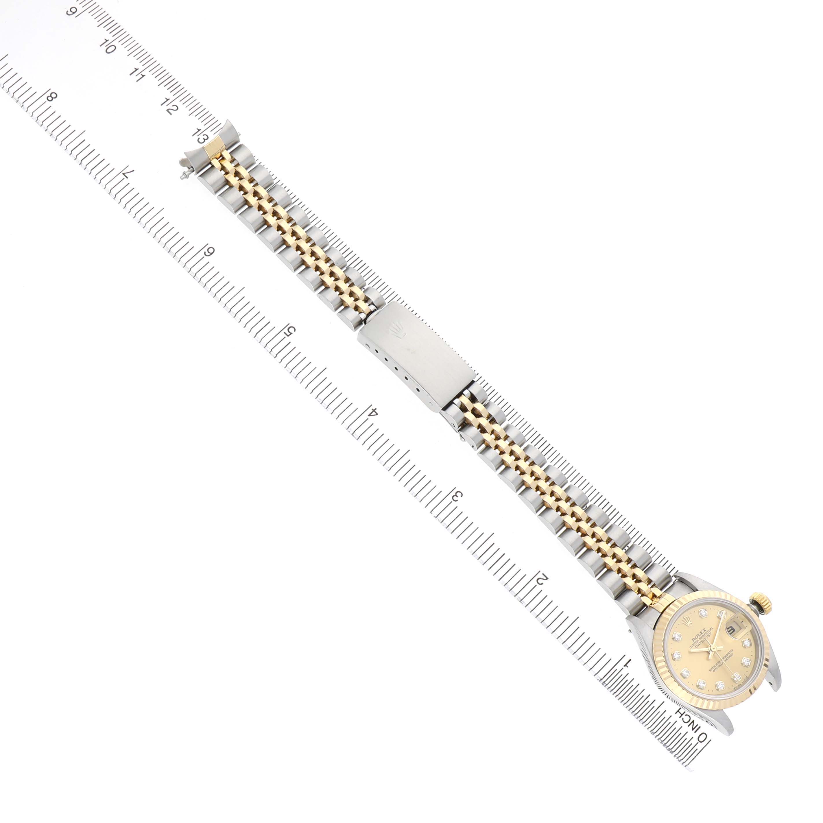 The image shows a top view of a Rolex Datejust 69173 Women's Steel and Gold (two tone) Champagne Dial watch with a two-tone bracelet and ruler for scale.