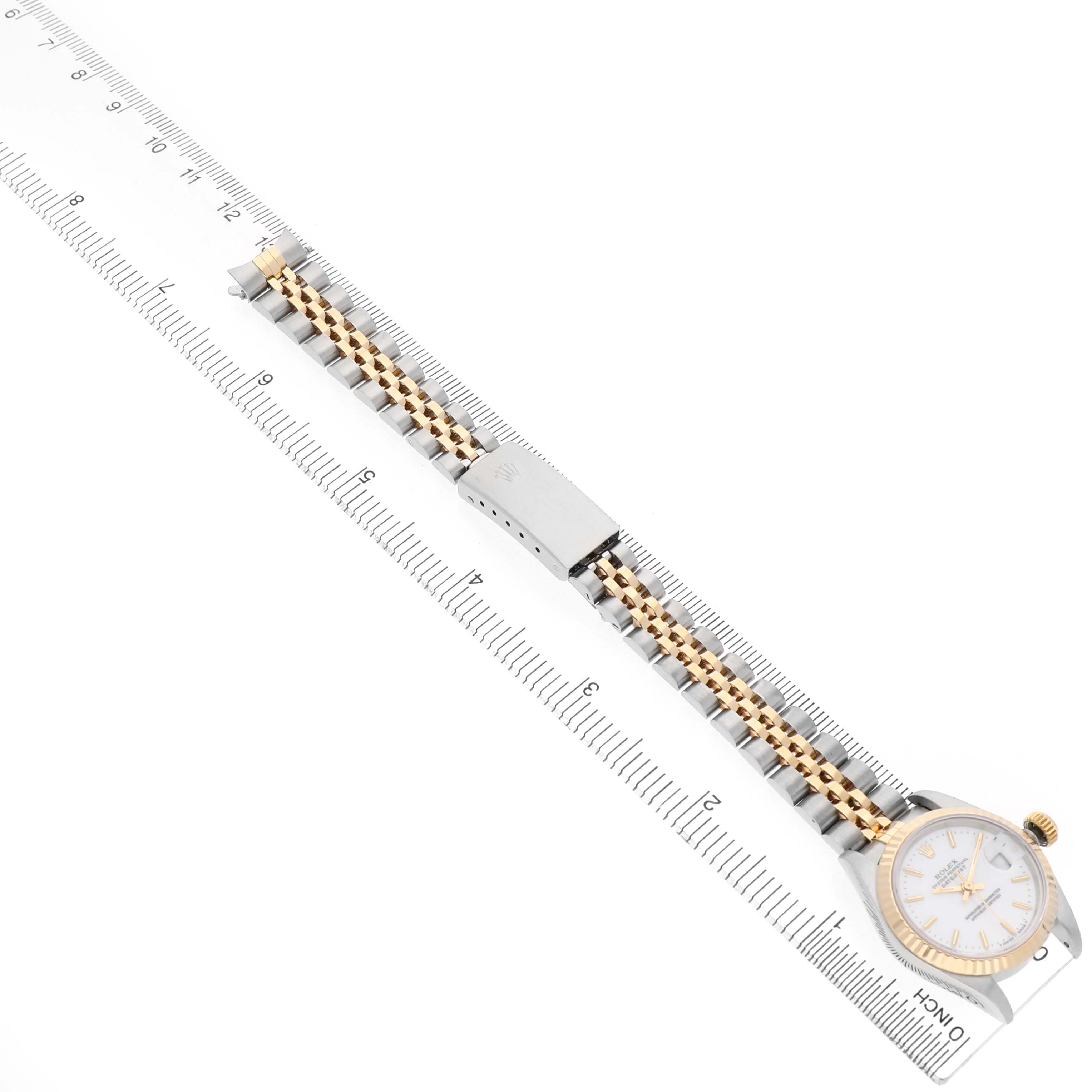 The image shows a Rolex Datejust 69173 Men's Steel and Gold (two tone) White Dial watch angled to display the entire band, including the clasp and the watch face, alongside a ruler.