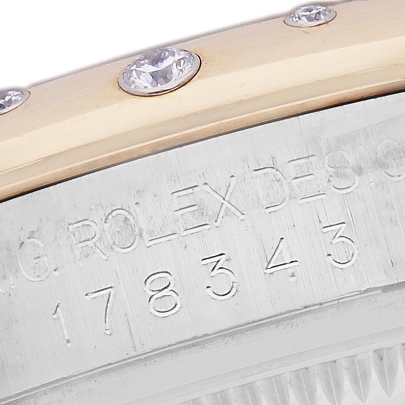 The image shows a close-up of a Rolex Mid-Size 278343 Women's Steel and Gold (two tone) Champagne Dial 278343 Women's Steel and Gold (two tone) Champagne Dial watch, focusing on the engraved bezel and diamond accents.