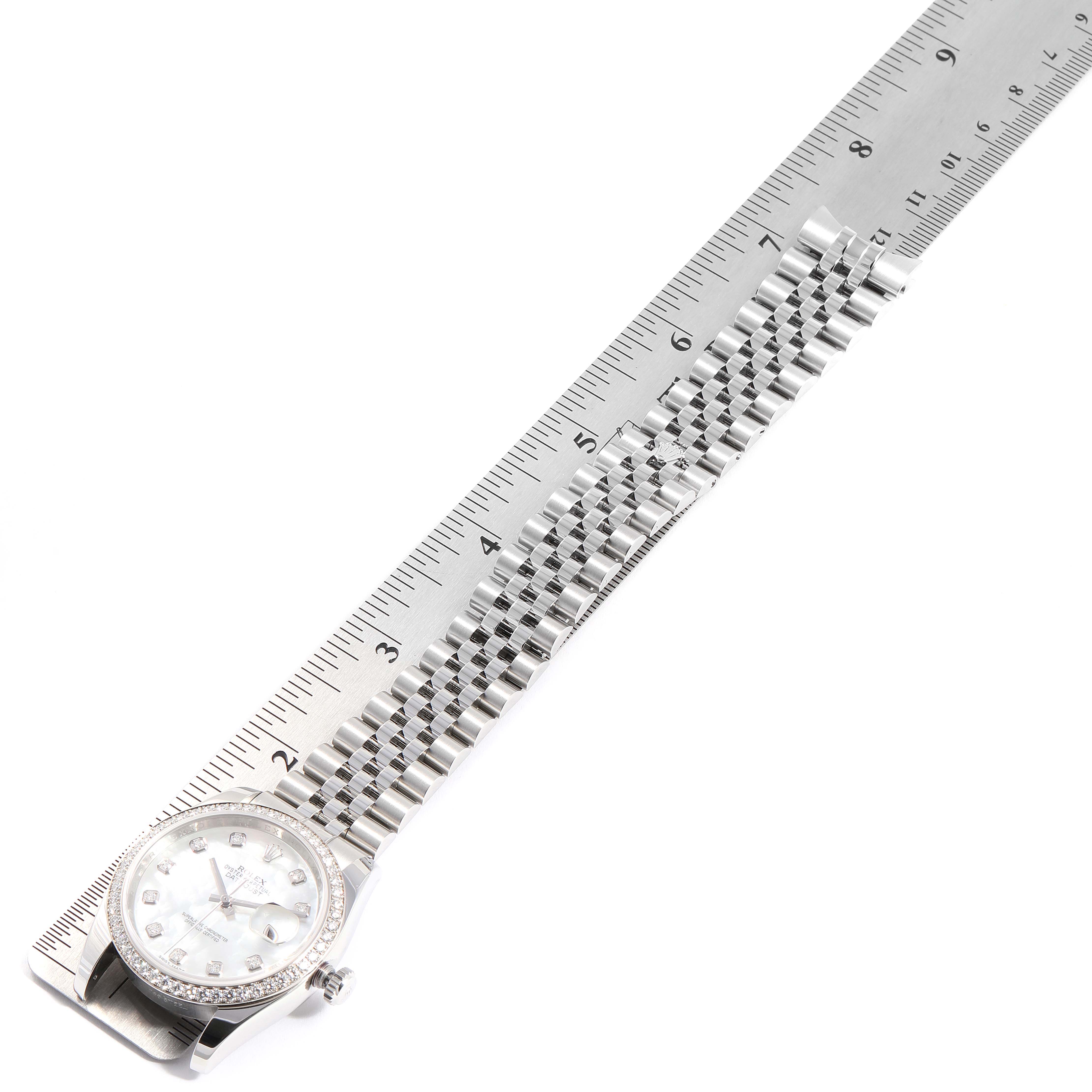 This image shows a Rolex Datejust 116244 Men's Stainless Steel Mother of Pearl Dial 116244 Men's Stainless Steel Mother of Pearl Dial watch laid flat next to a ruler, focusing on the face and bracelet.