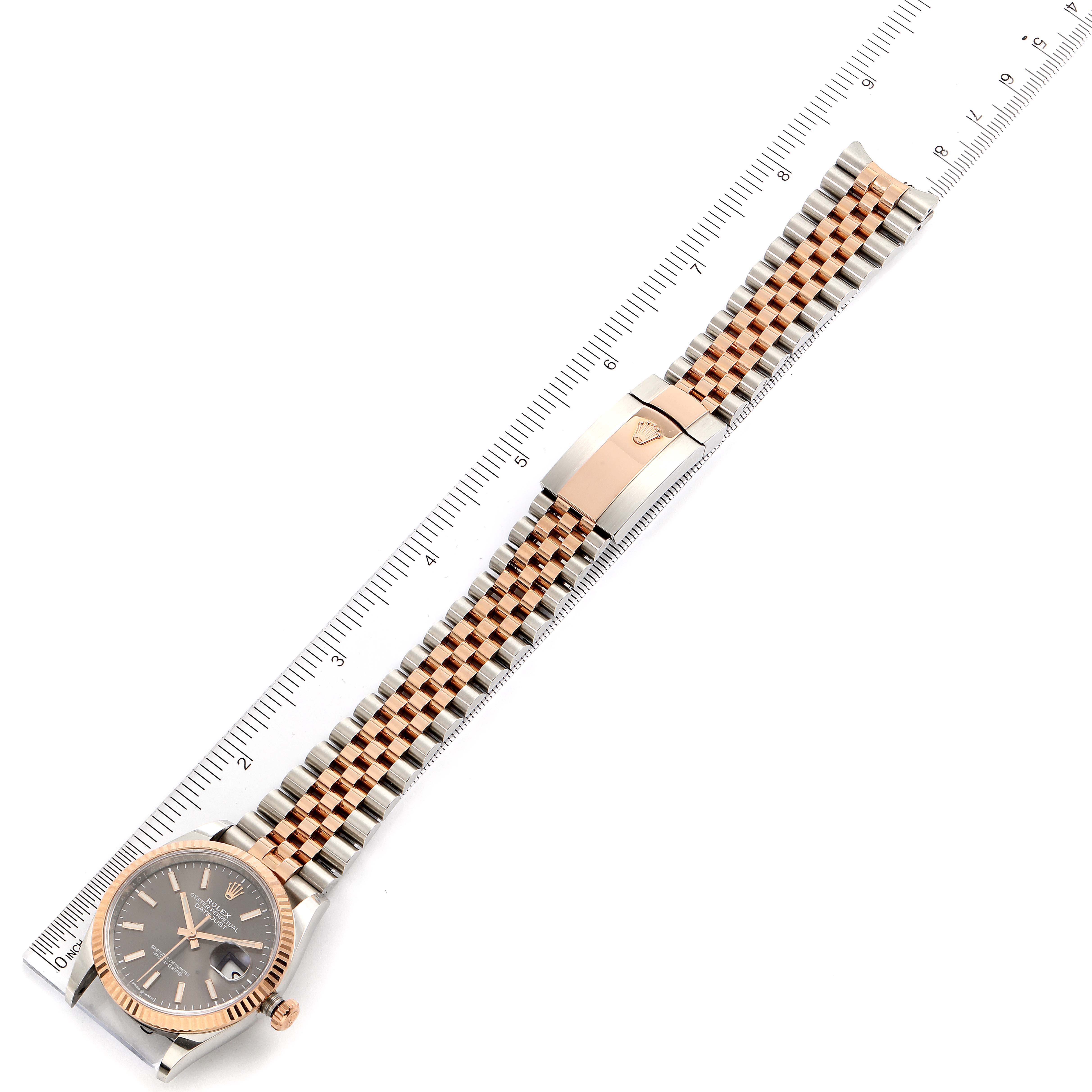 This image shows a full-length view of the Rolex Datejust 126231 Men
s Steel and Gold (two tone) Grey Dial 126231 Men
s Steel and Gold (two tone) Grey Dial watch, including the dial, bracelet, and clasp, alongside a measuring ruler.