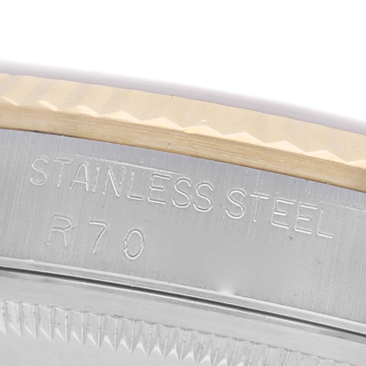 The image shows a close-up side view of the engraving on the Rolex Datejust 16233 Men's Steel and Gold (two tone) Champagne Dial 16233 Men's Steel and Gold (two tone) Champagne Dial's stainless steel case and bezel edge.