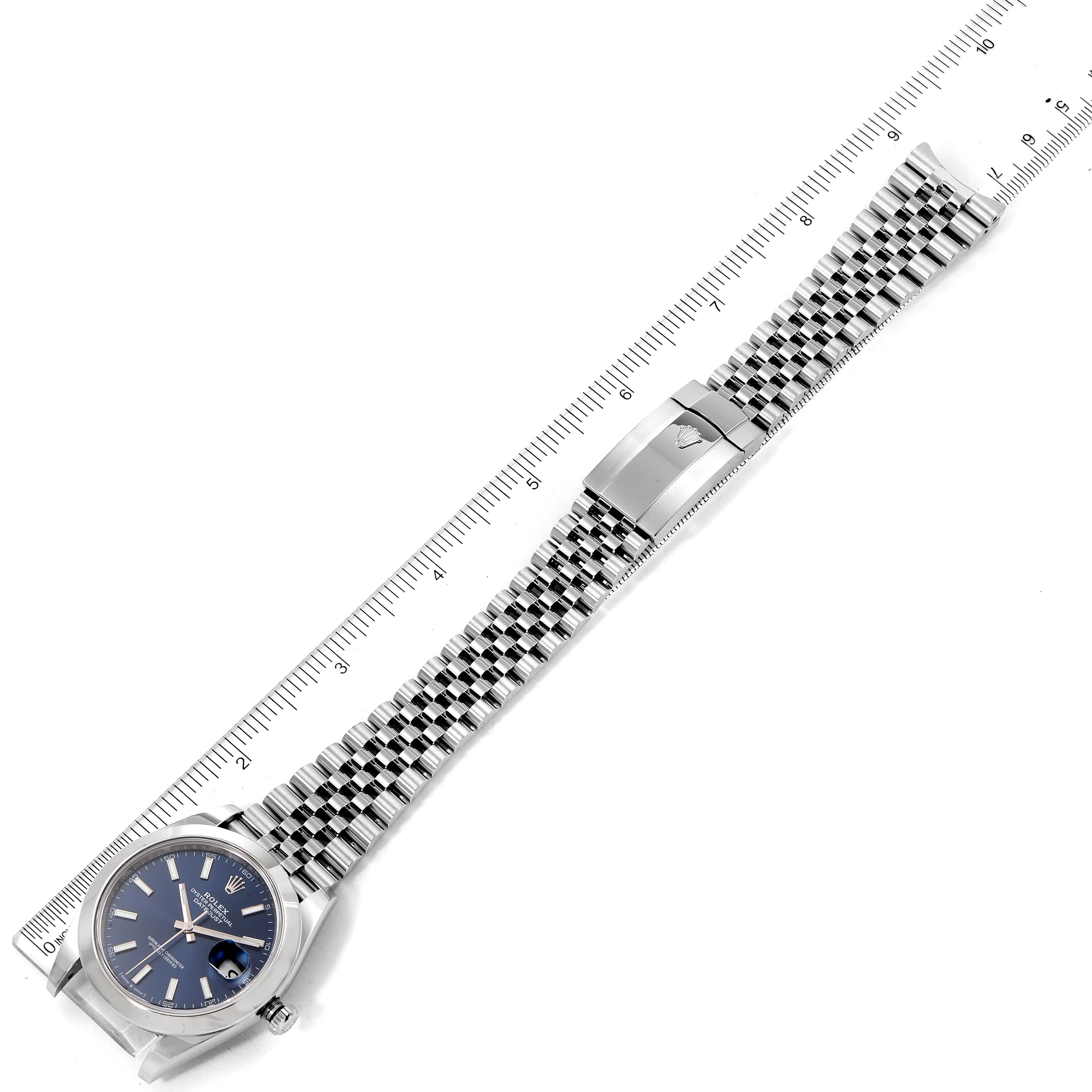 The image shows a Rolex Datejust 41 126300 Men's Stainless Steel Blue Dial 126300 Men's Stainless Steel Blue Dial watch laid flat with its dial and full bracelet visible next to a measuring ruler.
