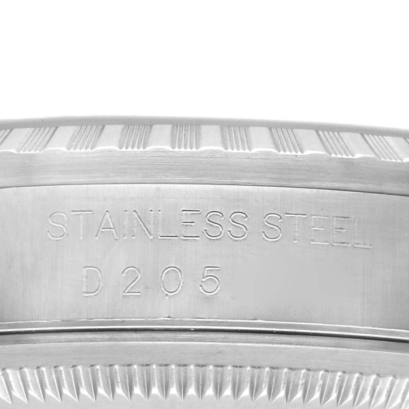 The image shows a close-up of the fluted bezel and side case of a Rolex Datejust 16220 Men's Stainless Steel Blue Dial, highlighting the "Stainless Steel" engraving.