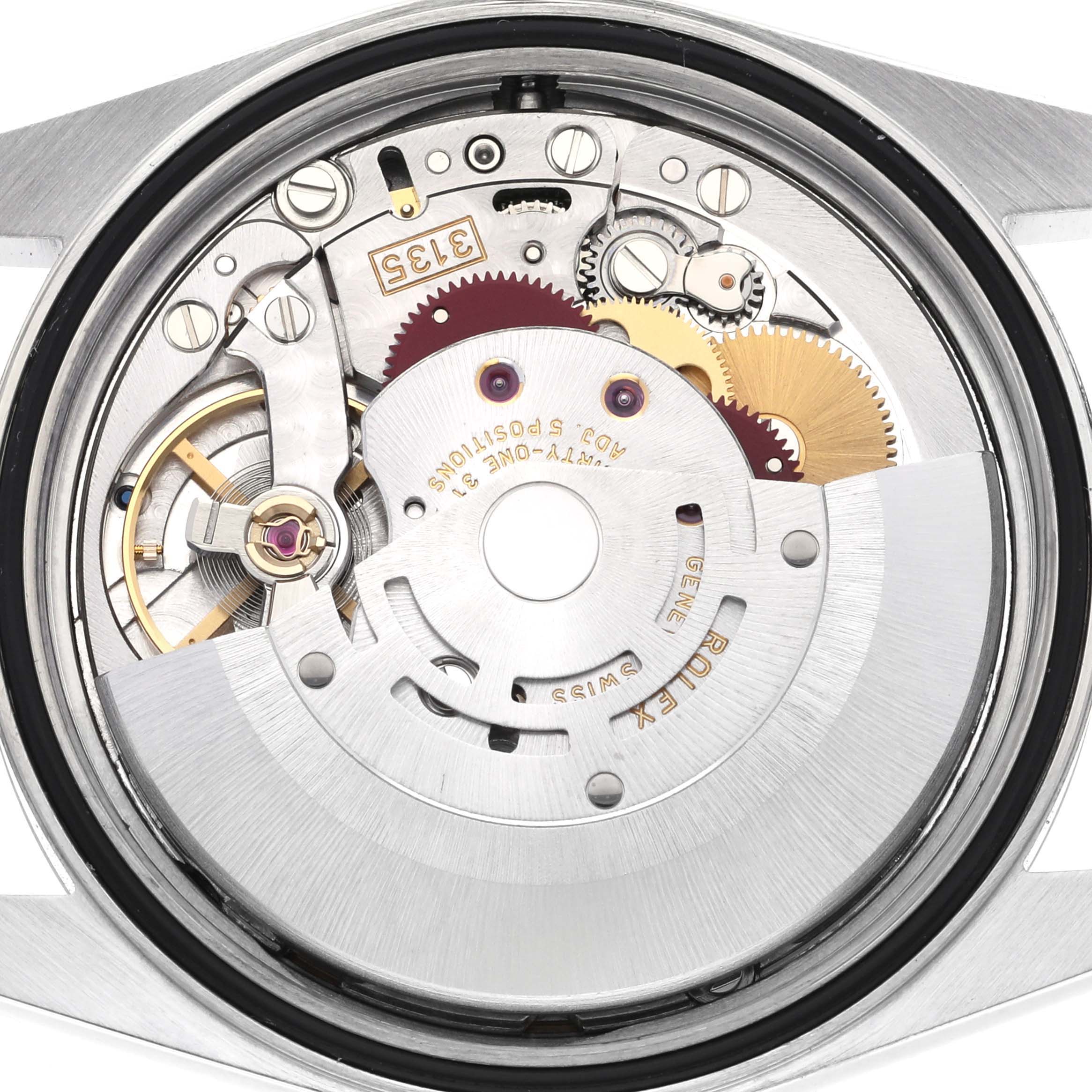 The image shows the internal mechanism of a Rolex Datejust 16220 Men's Stainless Steel Blue Dial watch viewed from the back, highlighting the movement and gears.