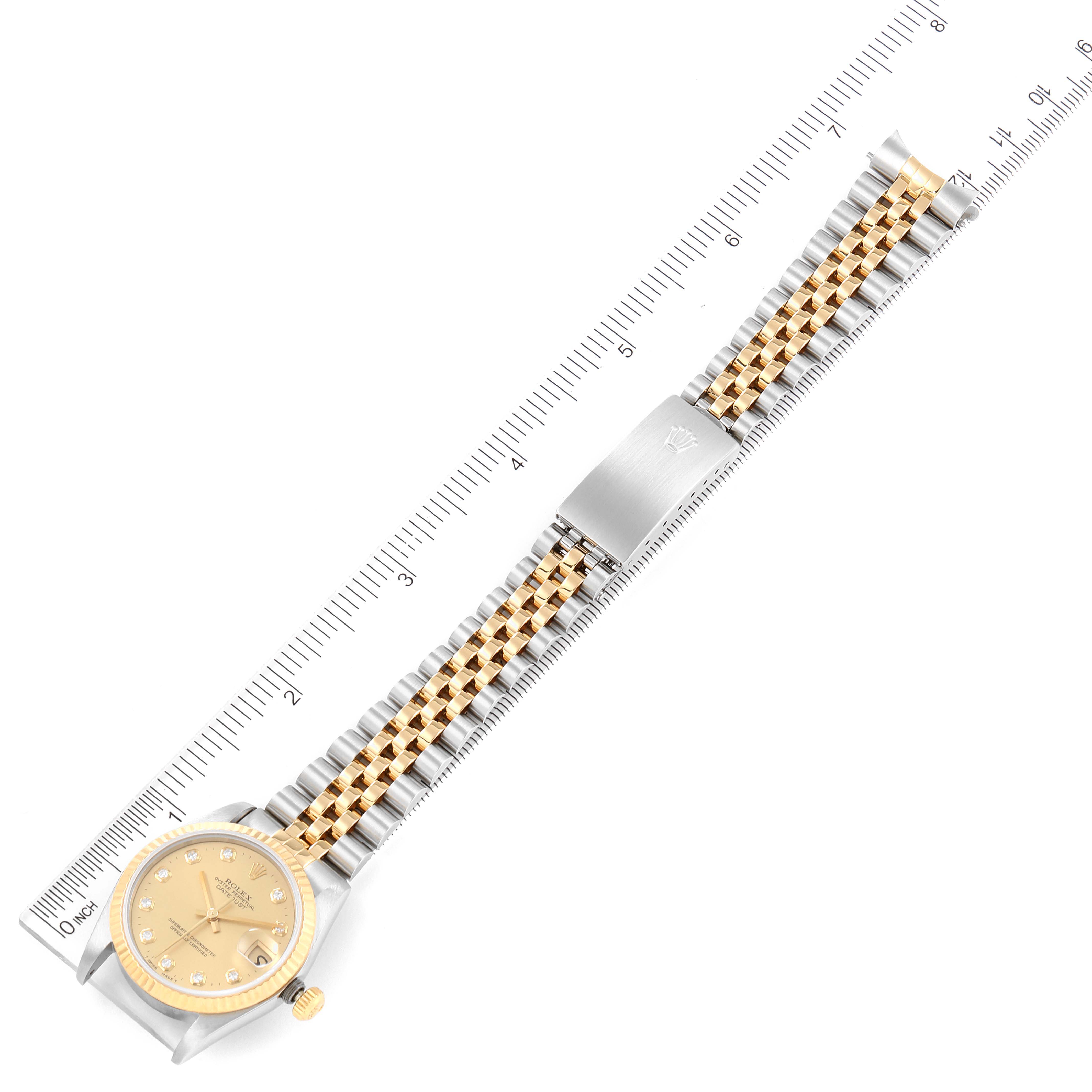 The image shows a top-down view of a Mid-Size Rolex watch with a two-tone bracelet next to a ruler for scale.