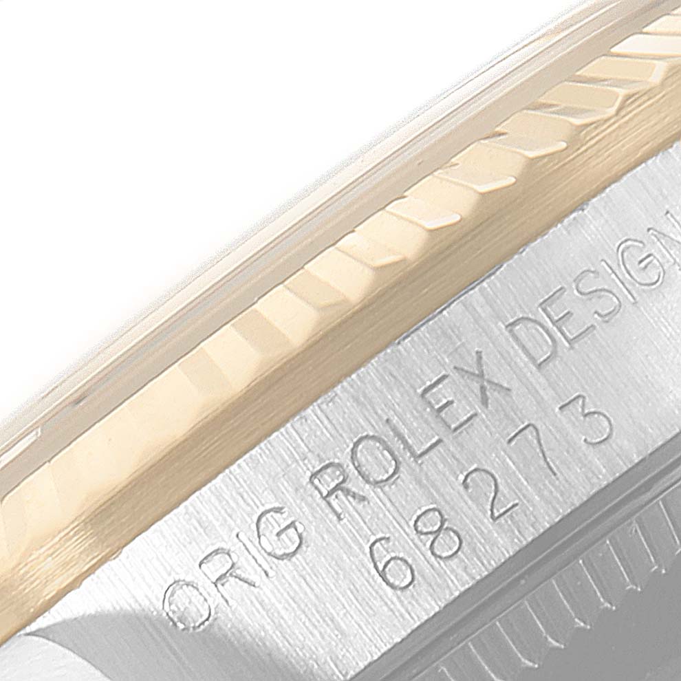 The image shows a close-up view of the side of a Mid-Size Rolex watch, focusing on the model number and edge of the bezel.