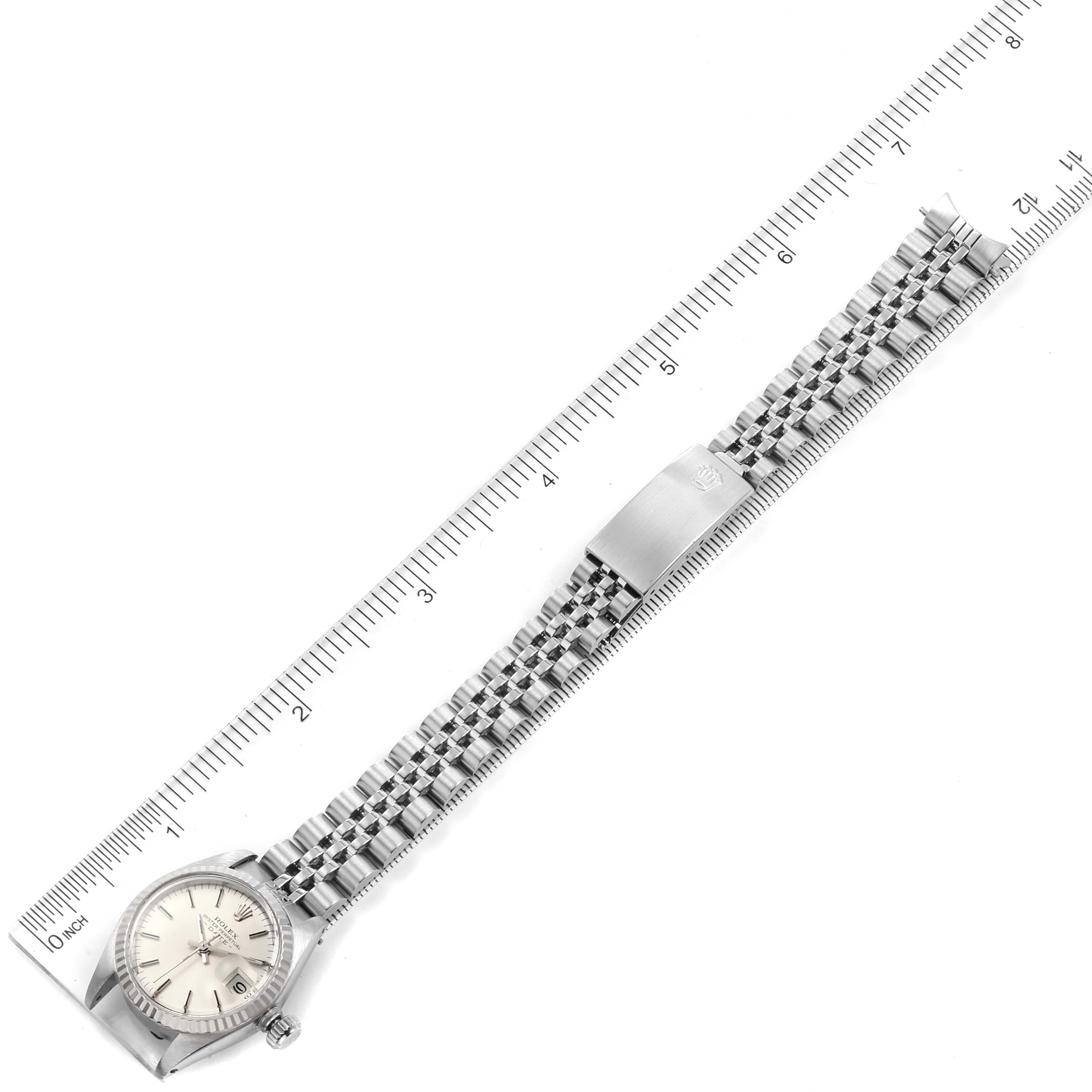 The image shows a top-down view of a Rolex Datejust 6917 Women's Stainless Steel Silver Dial 6917 Women's Stainless Steel Silver Dial model watch, displaying the face, bracelet, and clasp placed alongside a ruler.