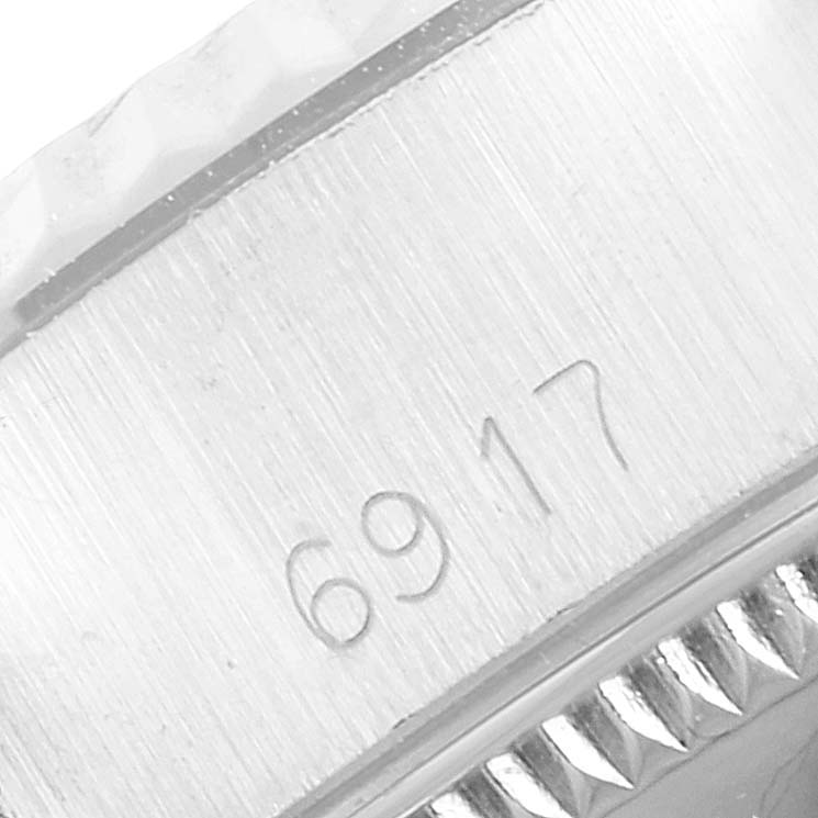 The image shows a close-up angle of the side of the Rolex Datejust 6917 Women's Stainless Steel Silver Dial 6917 Women's Stainless Steel Silver Dial watch case, focusing on the engraved serial number.