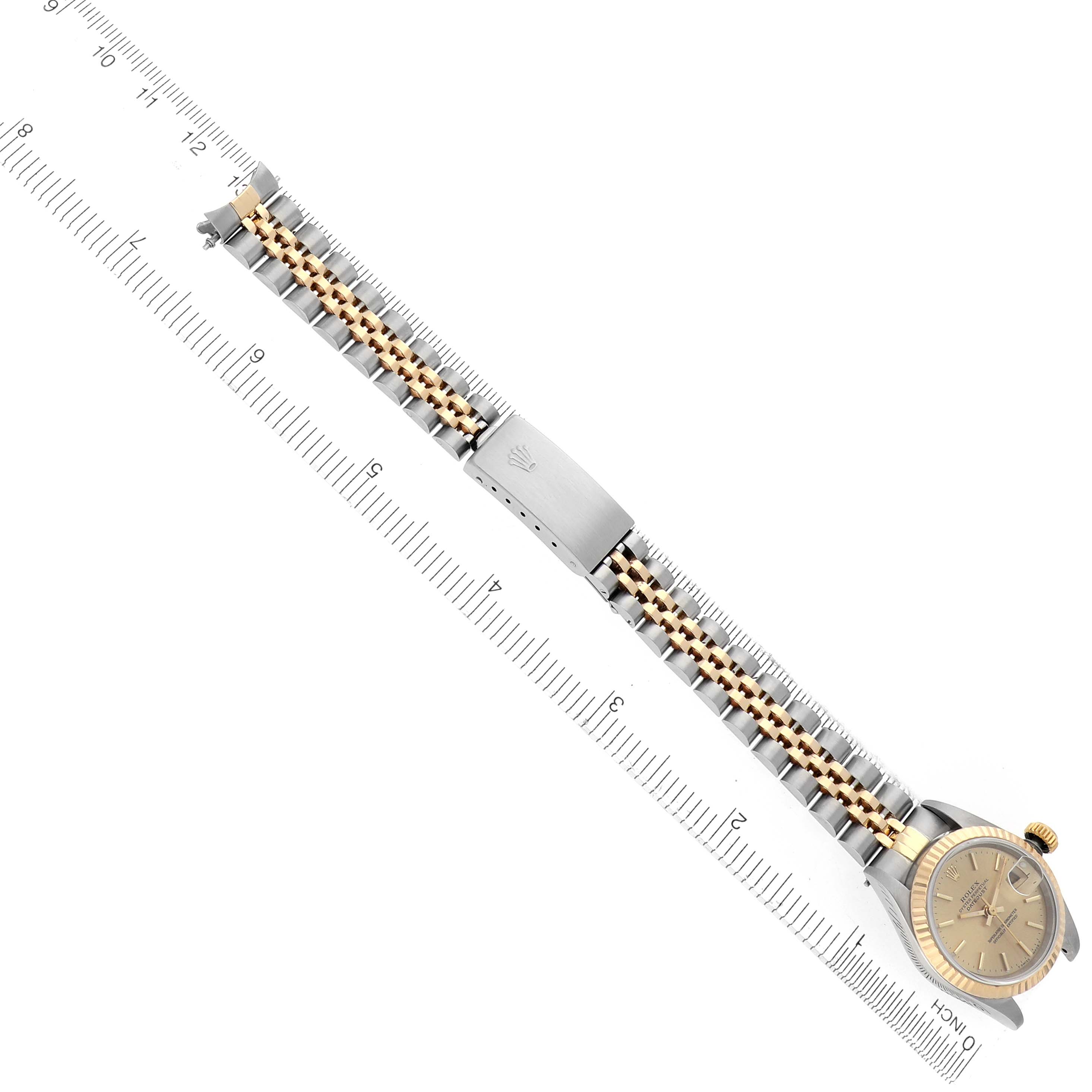 The image shows a Rolex Datejust 69173 Women's Steel and Gold (two tone) Champagne Dial 69173 Women's Steel and Gold (two tone) Champagne Dial watch from a top-down angle, highlighting the dial, crown, and linked bracelet alongside a ruler.