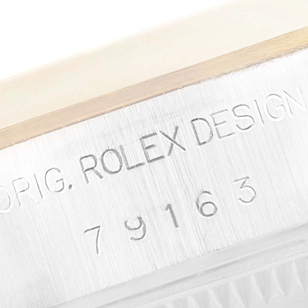 The image shows a close-up angle of the engraved serial number and "Rolex Design" on the side of a Rolex Datejust 79163 Women's Steel and Gold (two tone) Silver Dial 79163 Women's Steel and Gold (two tone) Silver Dial watch case.