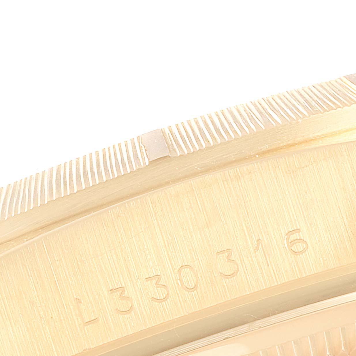 This close-up image shows the fluted bezel and part of the engraved serial number of a Rolex President 18248 Men
s Yellow Gold Champagne Dial 18248 Men
s Yellow Gold Champagne Dial model watch.