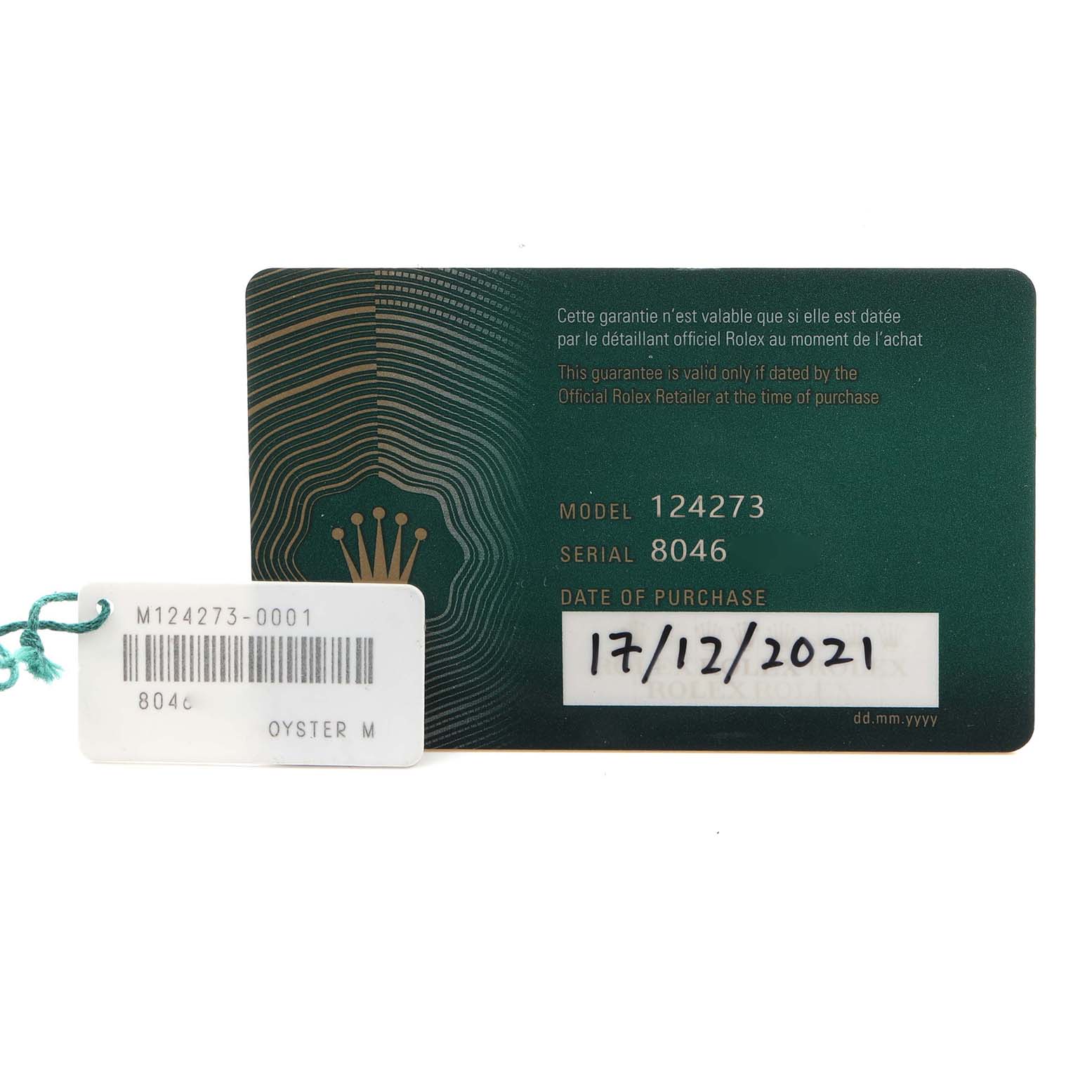 The image shows a warranty card and tag for the Rolex Explorer 124273 Men's Steel and Gold (two tone) Black Dial 124273 Men's Steel and Gold (two tone) Black Dial model 124273, displaying model numbers and purchase date.