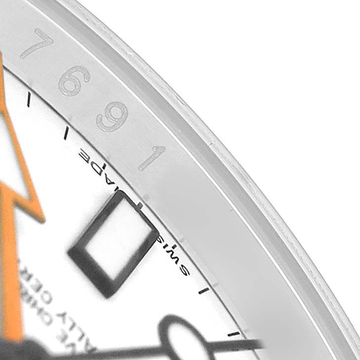 The image shows a close-up of the dial's edge, including the 6, 7, 9, 1 markers and part of the orange hand on the Rolex Explorer 216570 Men's Stainless Steel White Dial.