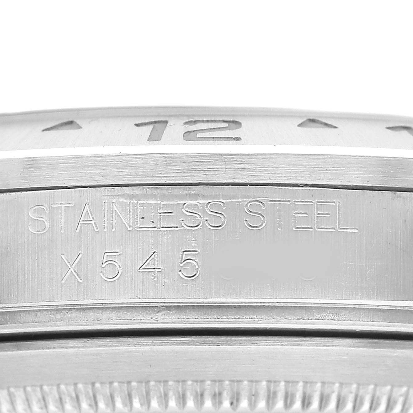 The image shows a close-up of the engraved stainless steel casing of a Rolex Explorer 16570 Men's Stainless Steel White Dial watch.