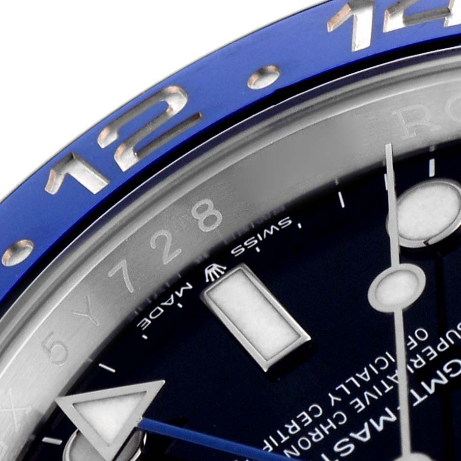 The image shows a close-up of the Rolex GMT-Master 126710 Men's Stainless Steel Black Dial 126710 Men's Stainless Steel Black Dial's bezel and dial, focusing on the 12 o'clock position with visible indices and hands.