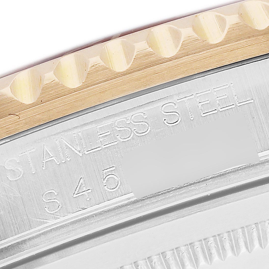 The image shows a close-up of the bezel and case edge of a Rolex GMT-Master 16713 Men's Steel and Gold (two tone) Brown Dial 16713 Men's Steel and Gold (two tone) Brown Dial, featuring "STAINLESS STEEL" engraving.