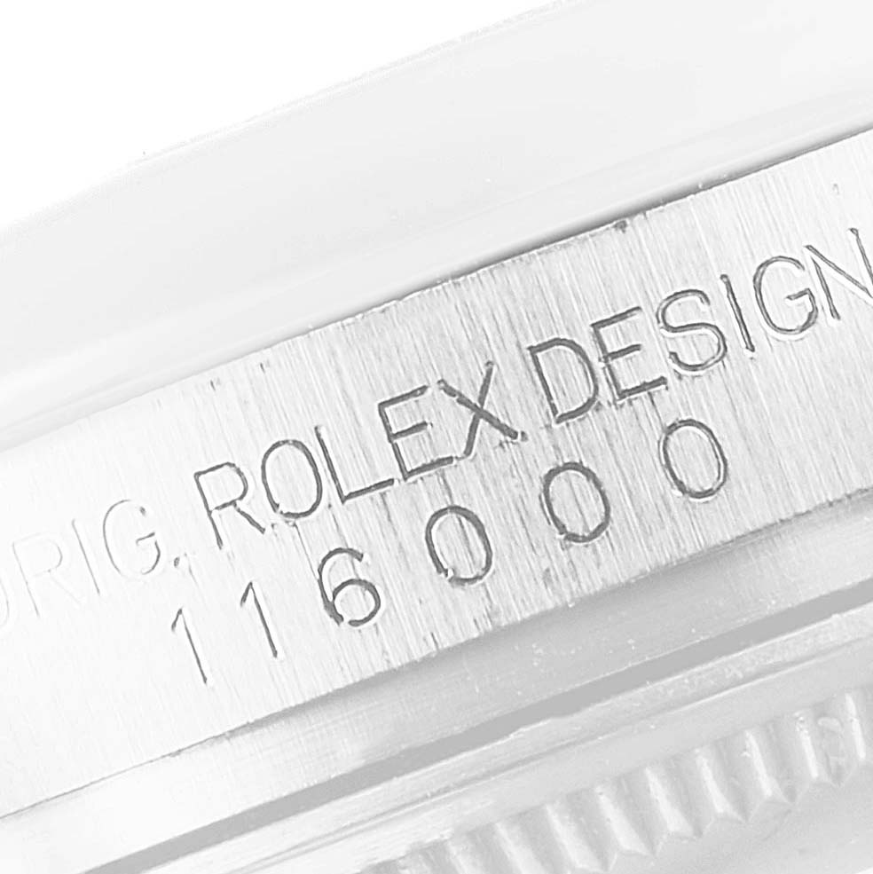 The image shows a close-up of the engraved model number and "Rolex Design" on the case rim of a Rolex Oyster Perpetual 116000 Men's Stainless Steel Silver Dial 116000 Men's Stainless Steel Silver Dial watch.