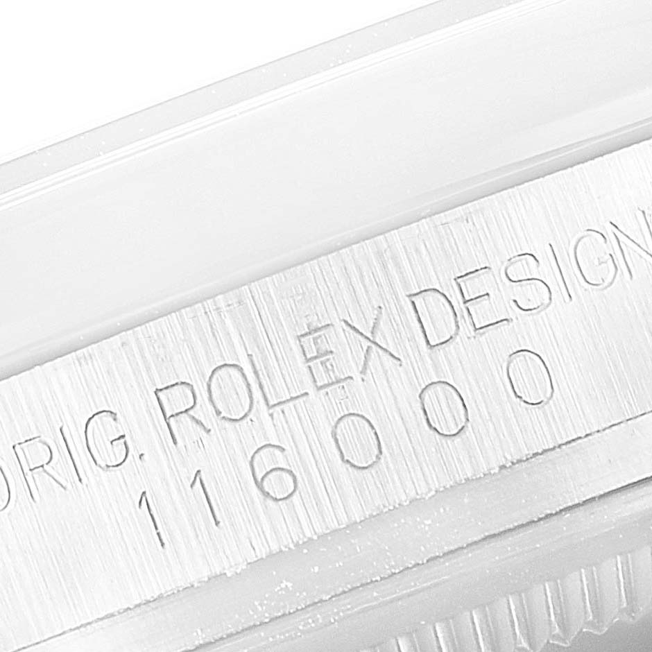 This image shows a close-up of the serial number engraving on the casing of a Rolex Oyster Perpetual 116000 Men's Stainless Steel Silver Dial 116000 Men's Stainless Steel Silver Dial watch.