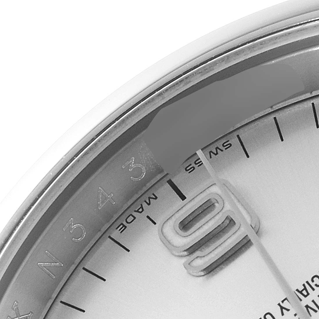 The image shows a close-up of the dial and bezel of a Rolex Oyster Perpetual 116000 Men's Stainless Steel Silver Dial 116000 Men's Stainless Steel Silver Dial watch, focusing on the 'Swiss Made' text and the 9 o'clock marker.