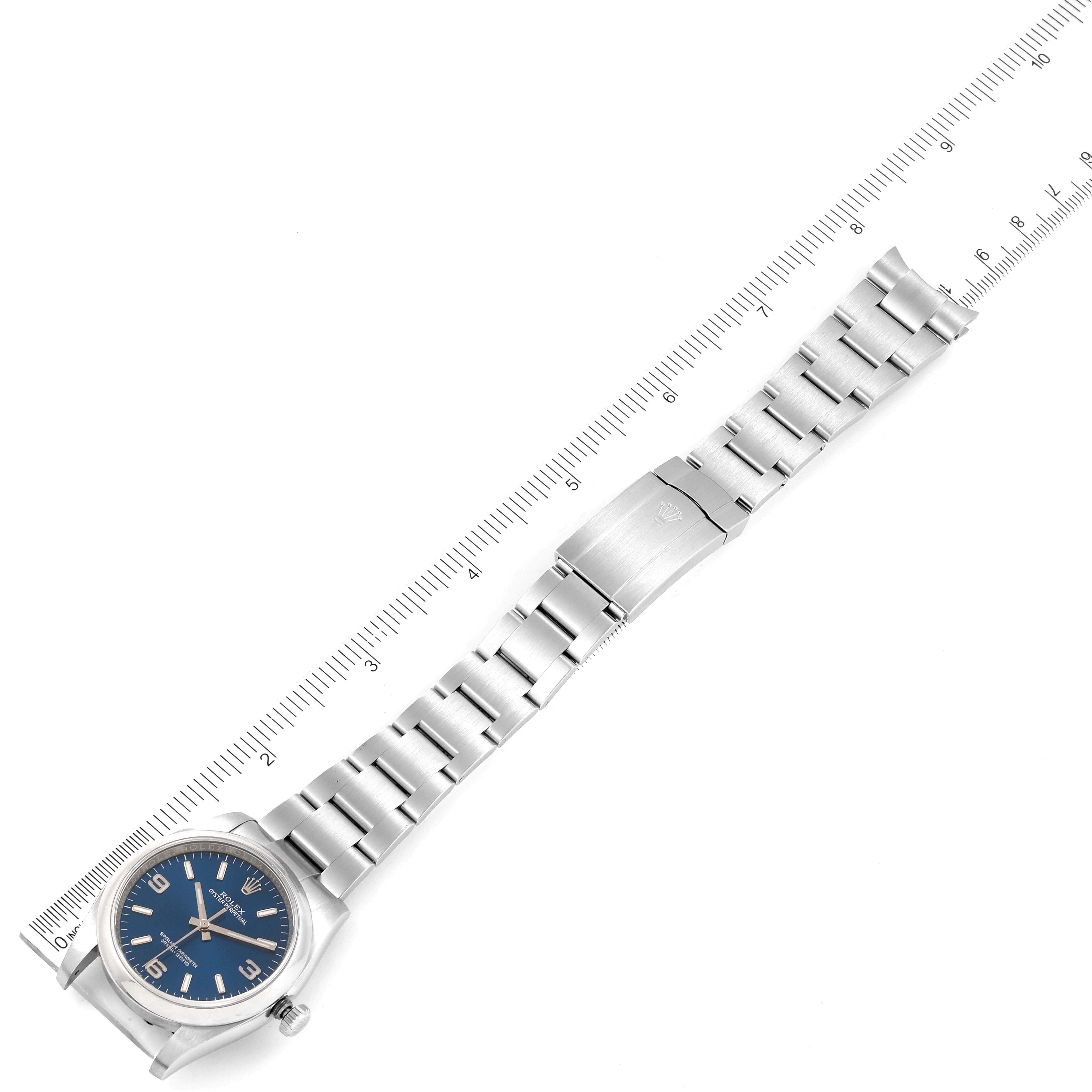 The Rolex Oyster Perpetual 116000 Men's Stainless Steel Blue Dial 116000 Men's Stainless Steel Blue Dial watch is shown from an aerial view, displaying the full length of the bracelet and the watch face.