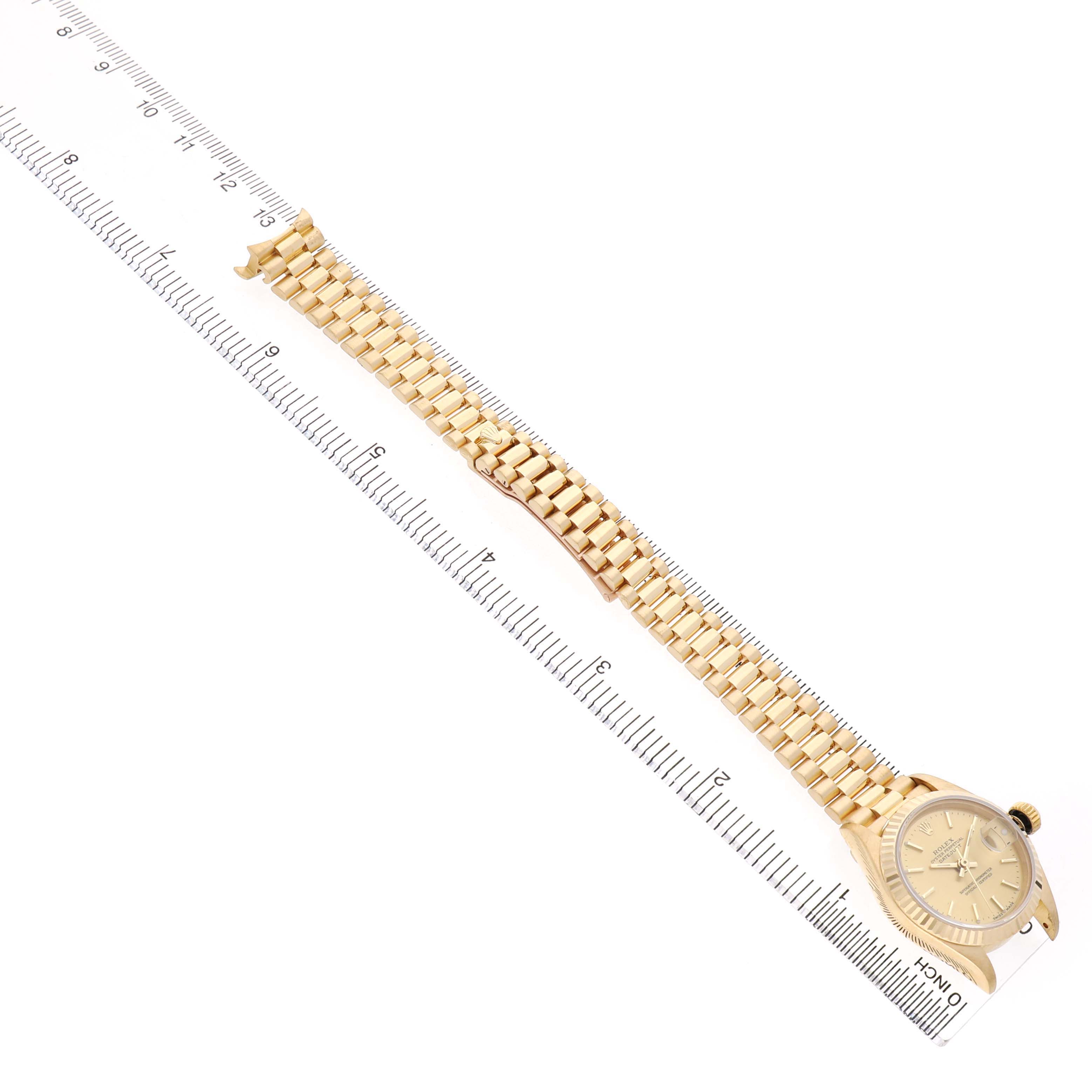 The image shows a Rolex President 69178 Women's Yellow Gold Champagne Dial model at an angle displaying the watch face and full bracelet aligned alongside a ruler.
