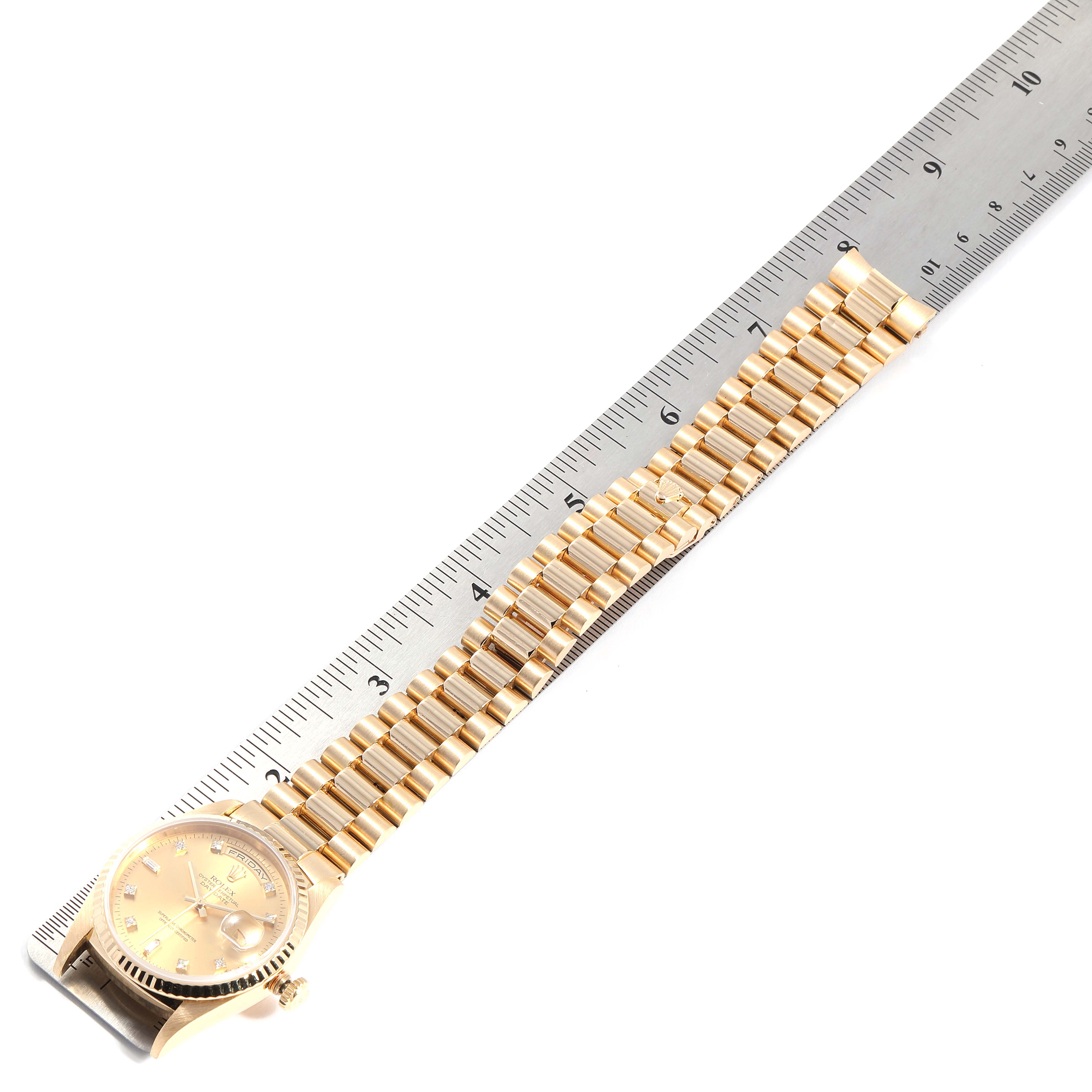 The image shows a Rolex President 18238 Men
s Yellow Gold Champagne Dial 18238 Men
s Yellow Gold Champagne Dial model watch with a gold bracelet laid flat next to a ruler for measurement.