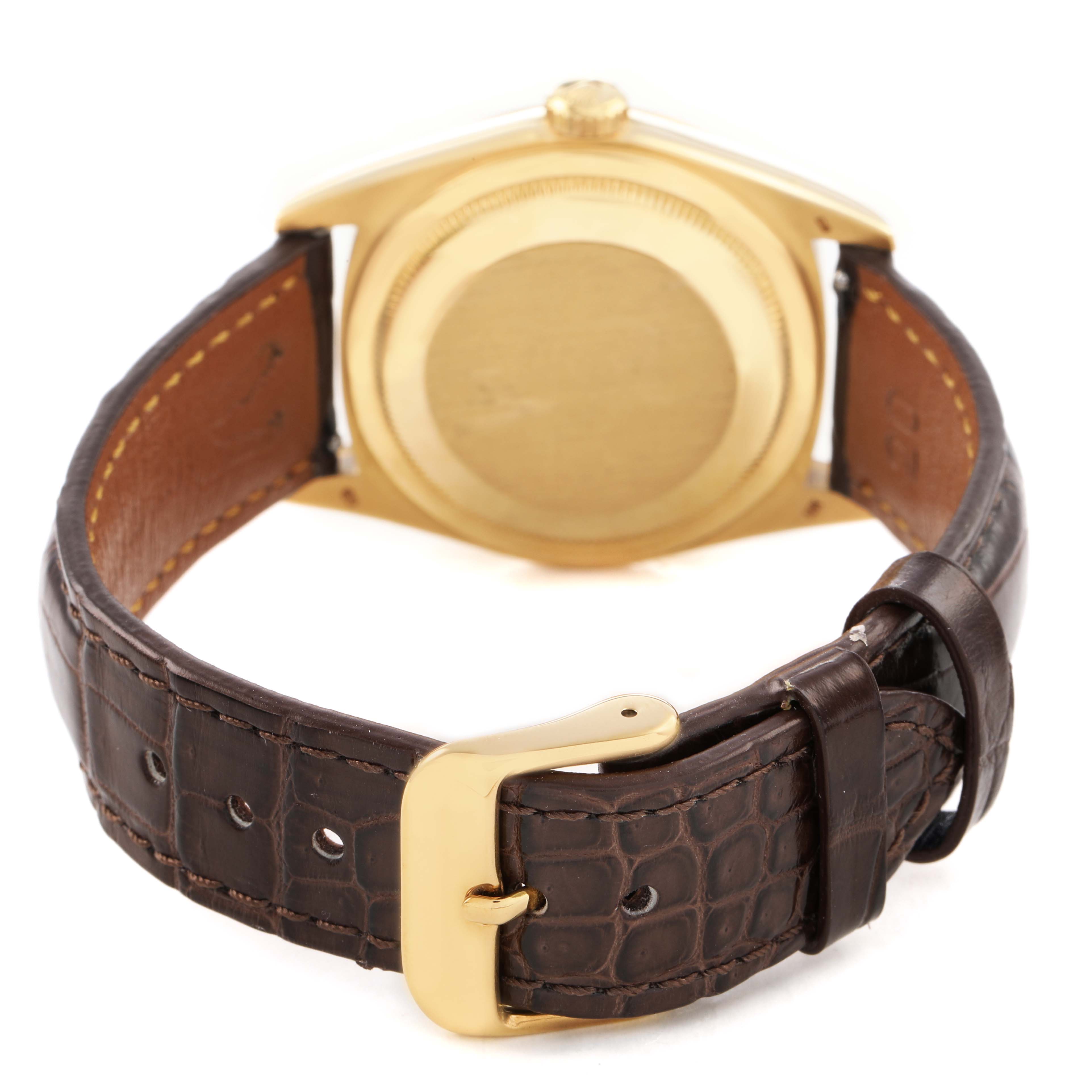 The image shows the back of a Rolex President 18238 Men's Yellow Gold Silver Dial watch with a focus on the golden case back and a brown leather strap.