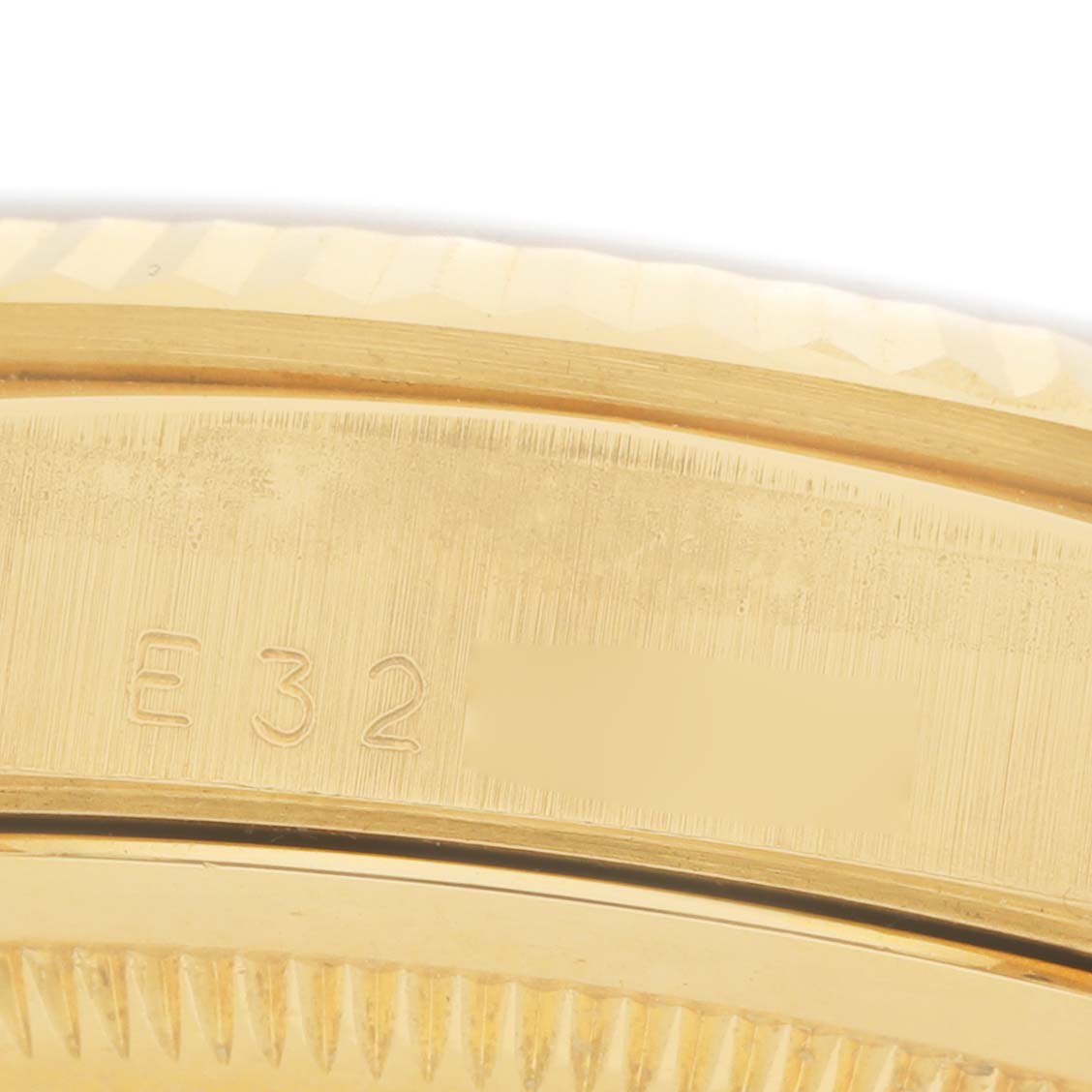 The image shows a close-up of the side of a Rolex President 18238 Men's Yellow Gold Silver Dial watch, highlighting the bezel and serial engravings.