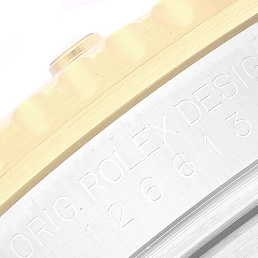 This image shows a close-up view of the bezel and engraved case of a Rolex Submariner 126613 Men's Steel and Gold (two tone) Blue Dial 126613 Men's Steel and Gold (two tone) Blue Dial watch.