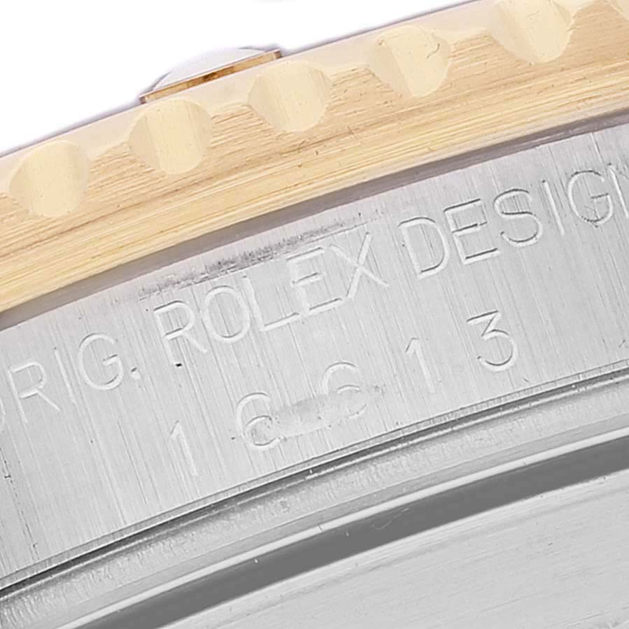 This close-up image shows the engraved edge of the bezel and case of a Rolex Submariner 16613 Men's Steel and Gold (two tone) Blue Dial 16613 Men's Steel and Gold (two tone) Blue Dial watch.