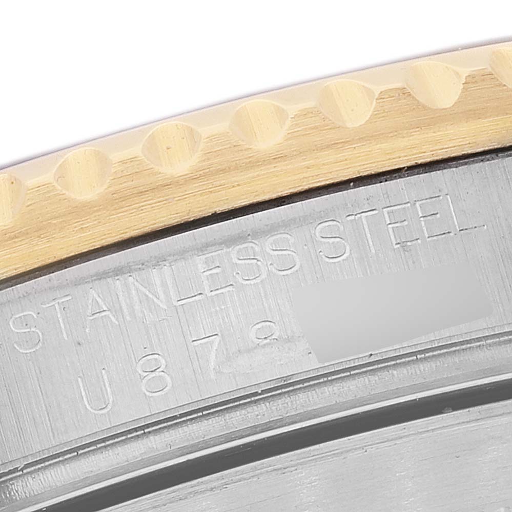 The image shows a partial close-up of the stainless steel back and edge of the bezel of a Rolex Submariner 16613 Men's Steel and Gold (two tone) Blue Dial 16613 Men's Steel and Gold (two tone) Blue Dial watch.