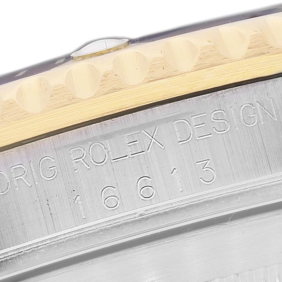 This image shows a close-up of the bezel and engraved case side of a Rolex Submariner 16613 Men's Steel and Gold (two tone) Blue Dial 16613 Men's Steel and Gold (two tone) Blue Dial watch.