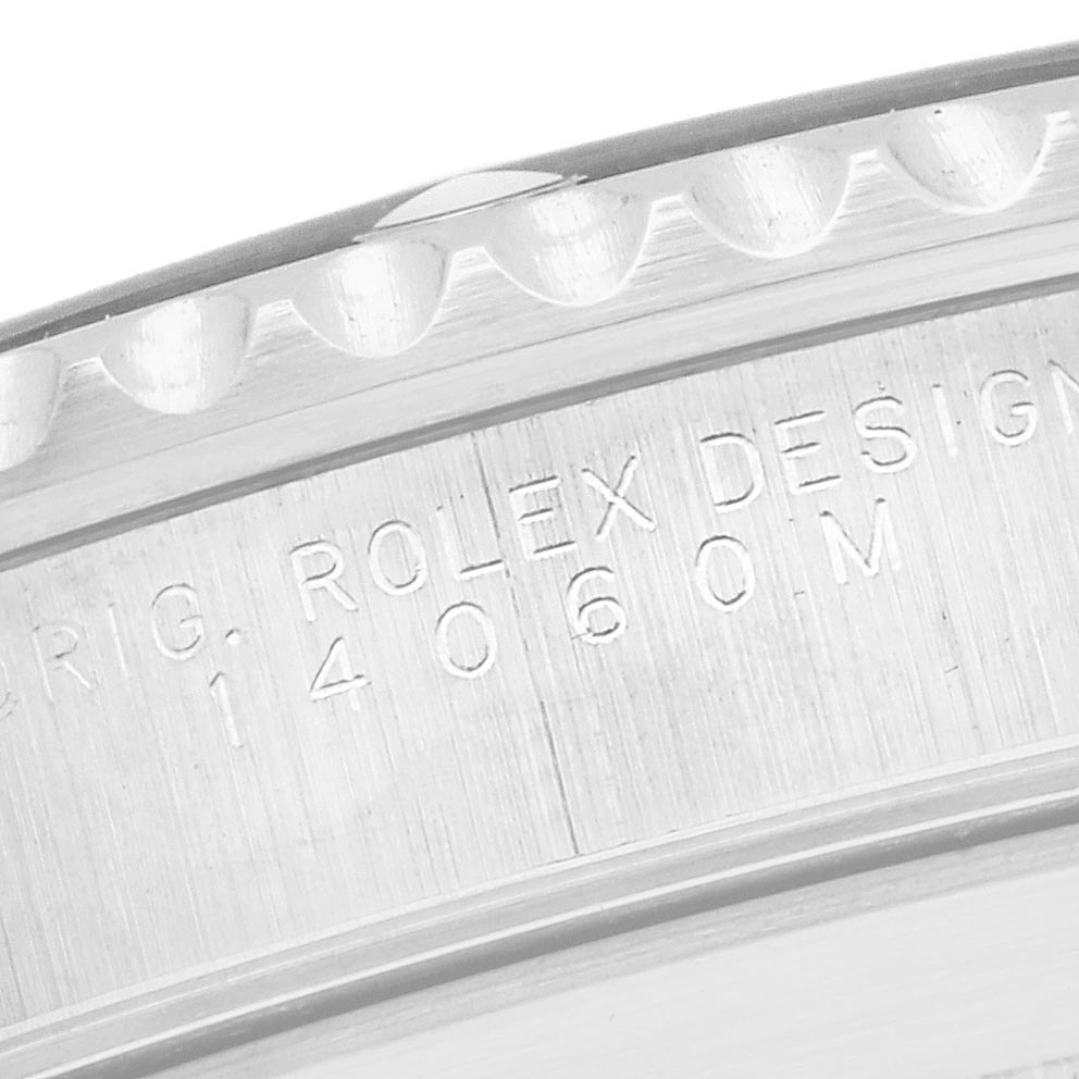 The image shows a close-up of the Rolex Submariner 14060 Men's Stainless Steel Black Dial 14060 Men's Stainless Steel Black Dial's engraved bezel and case edge.