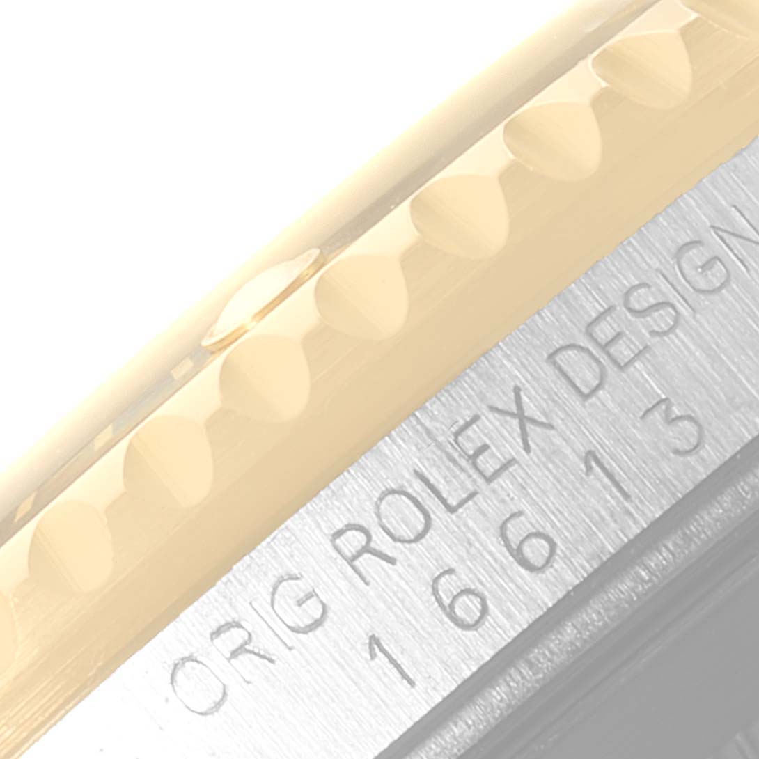 This close-up image of a Rolex Submariner 16613 Men's Steel and Gold (two tone) Black Dial 16613 Men's Steel and Gold (two tone) Black Dial shows the engraved reference number and part of the bezel edge.