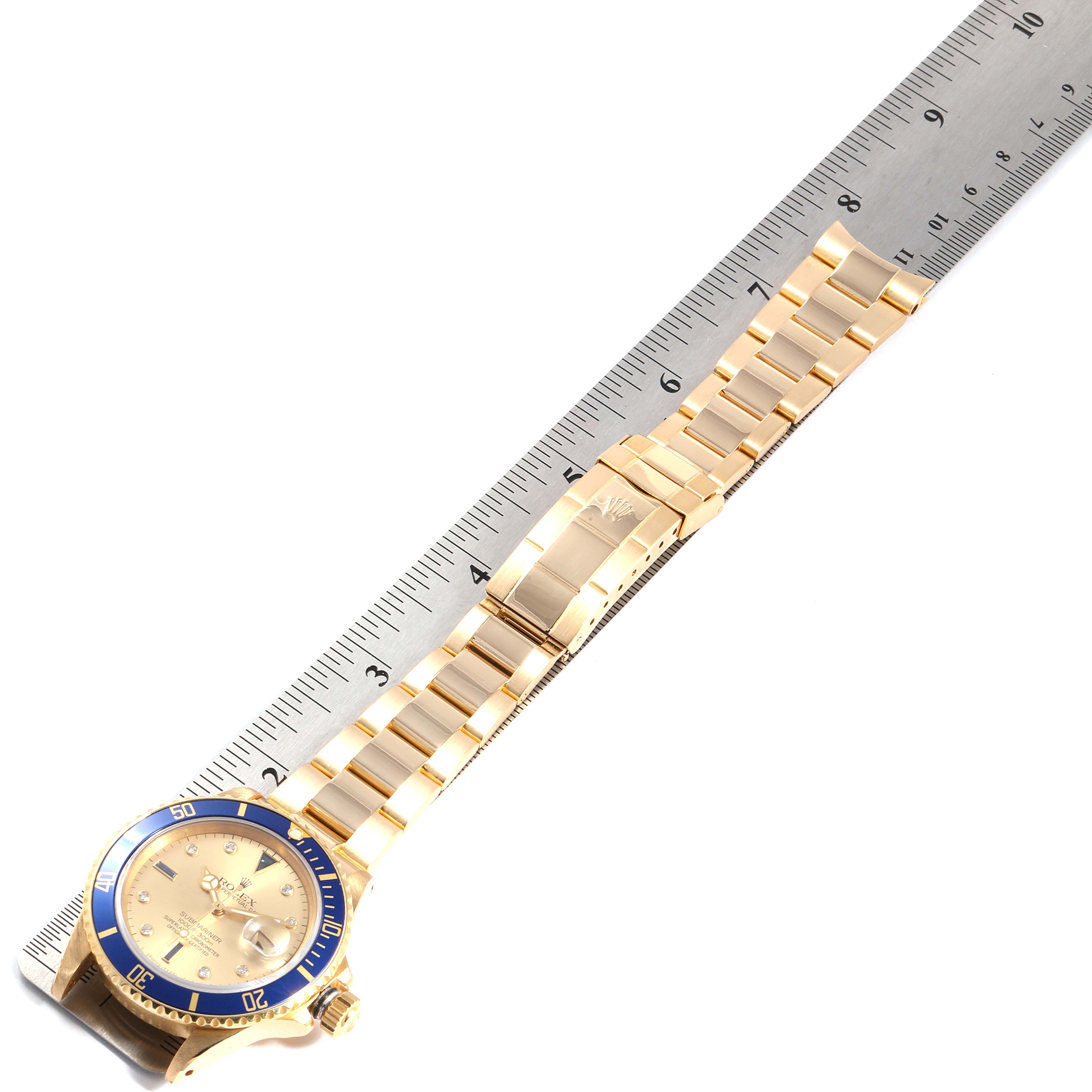 The image shows a Rolex Submariner 16808 Men's Yellow Gold Champagne Dial 16808 Men's Yellow Gold Champagne Dial watch laid flat with its gold bracelet extended next to a ruler for scale.