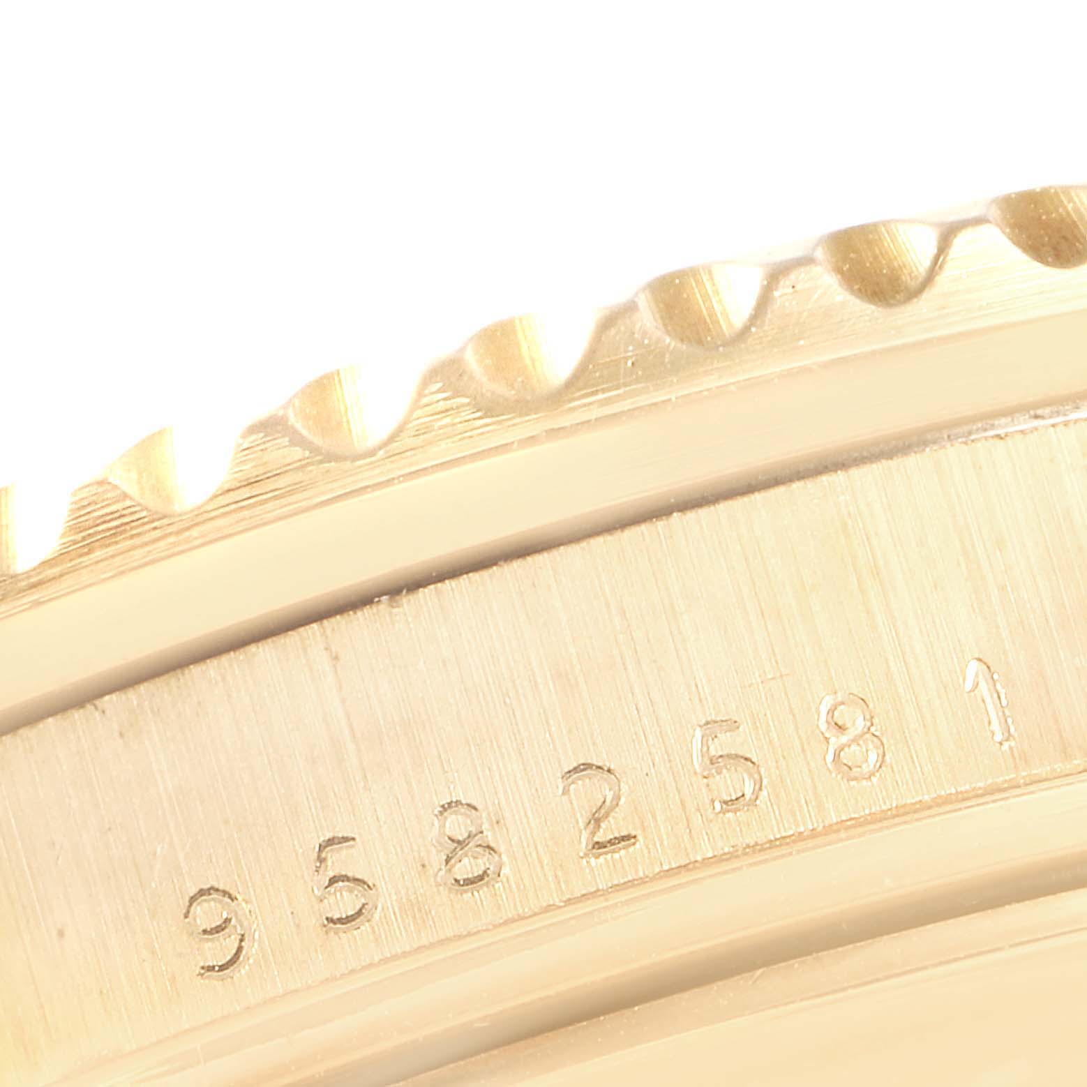 The image shows a close-up view of the serial number engraving and partial bezel of a Rolex Submariner 16808 Men's Yellow Gold Champagne Dial 16808 Men's Yellow Gold Champagne Dial watch.