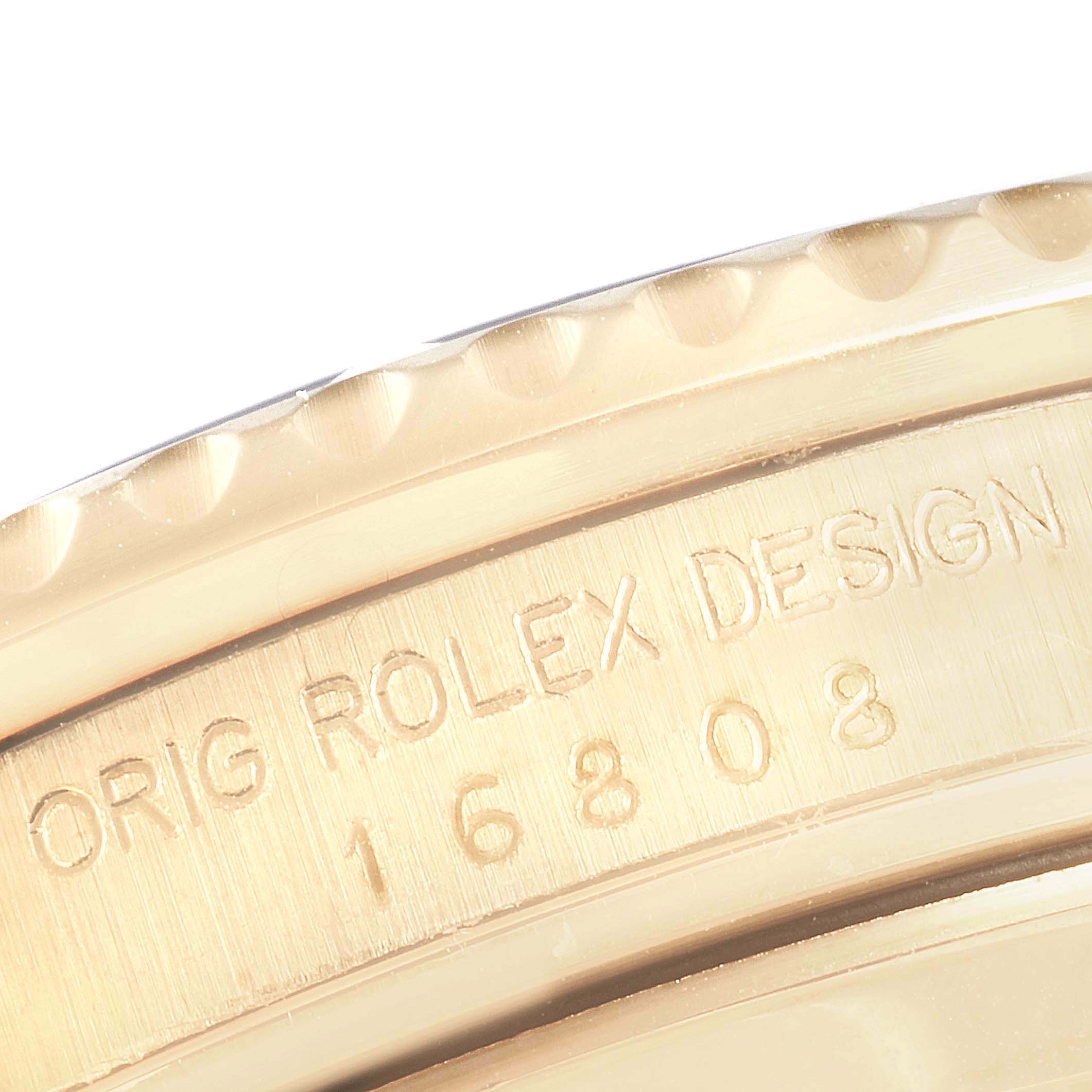 This close-up image shows the engraved side of the bezel of a Rolex Submariner 16808 Men's Yellow Gold Champagne Dial 16808 Men's Yellow Gold Champagne Dial watch, displaying the model number 16808.