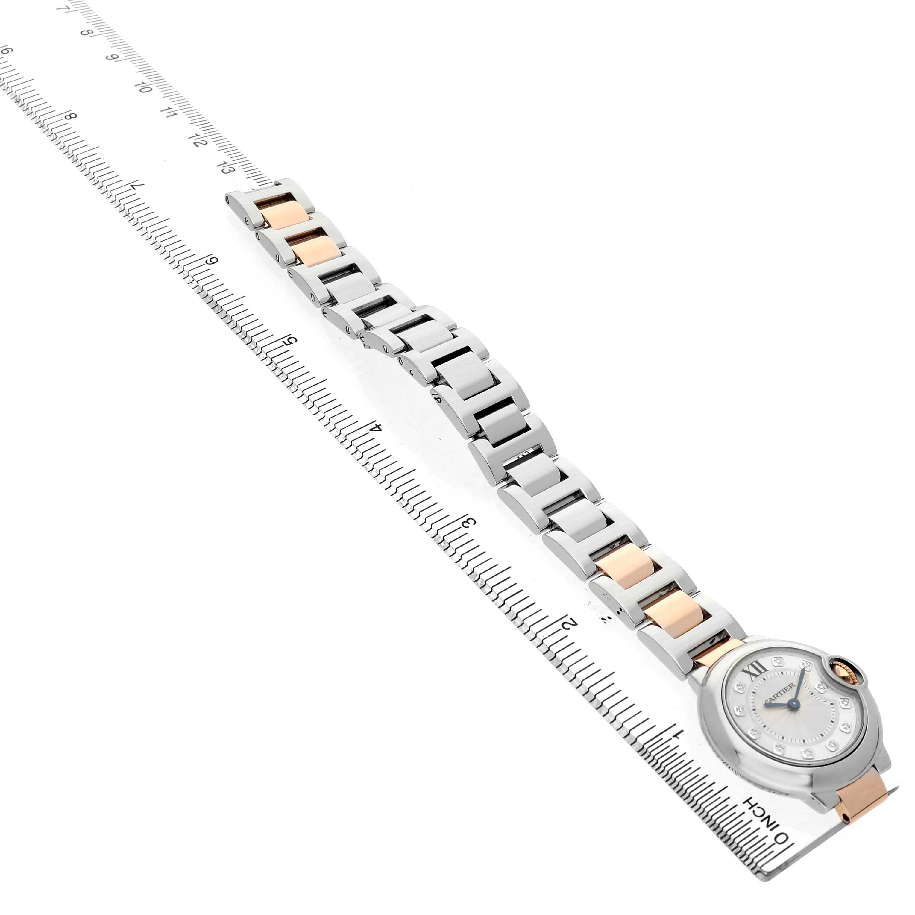 The Cartier Ballon Bleu WE902030 Women's Steel and Gold (two tone) Silver Dial watch is shown at an angle highlighting the face, case, and full bracelet aligned with a ruler.