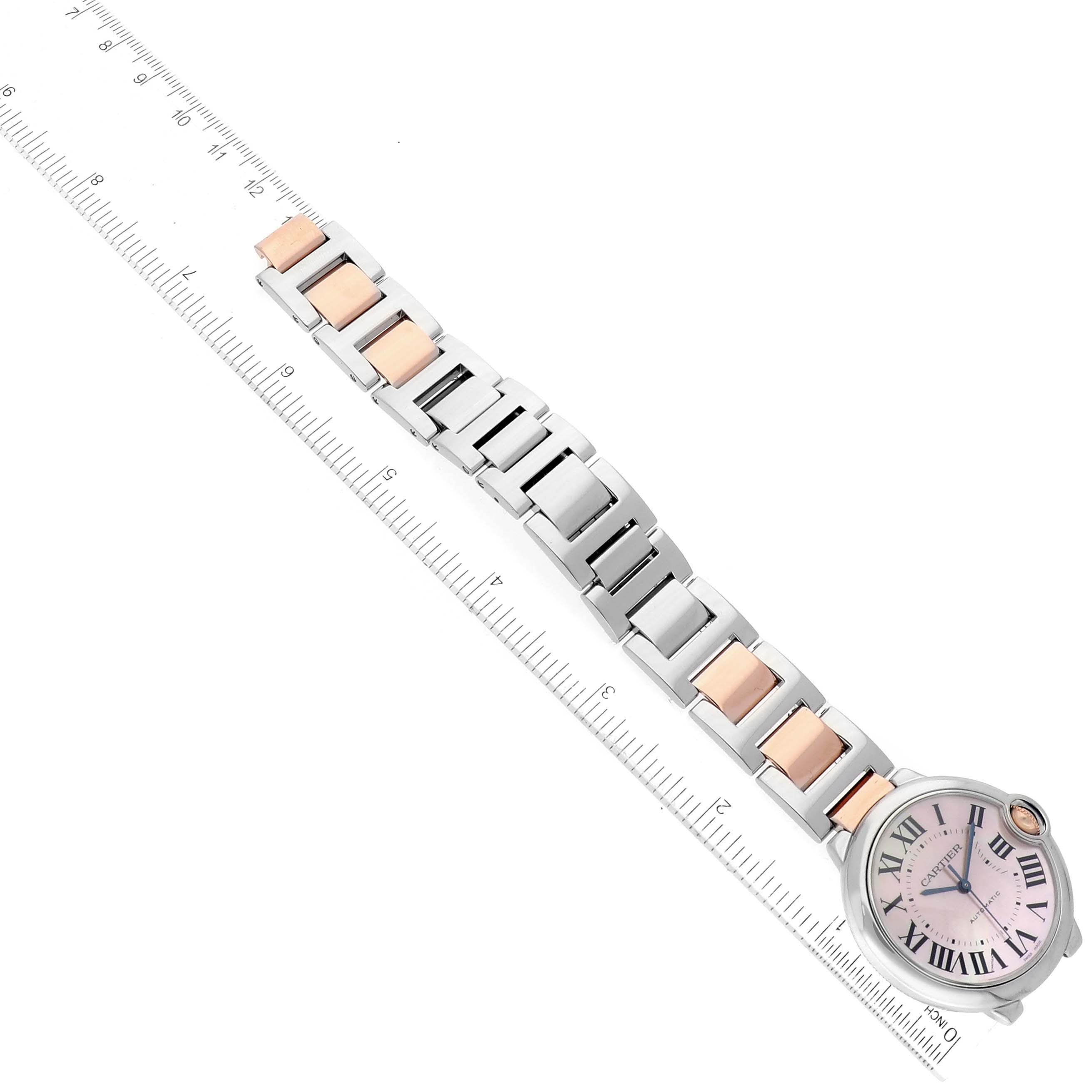 The image shows a Cartier Ballon Bleu W6920033 Women's Steel and Gold (two tone) Mother of Pearl Dial W6920033 Women's Steel and Gold (two tone) Mother of Pearl Dial watch with a two-tone bracelet, positioned alongside a ruler for measurement.