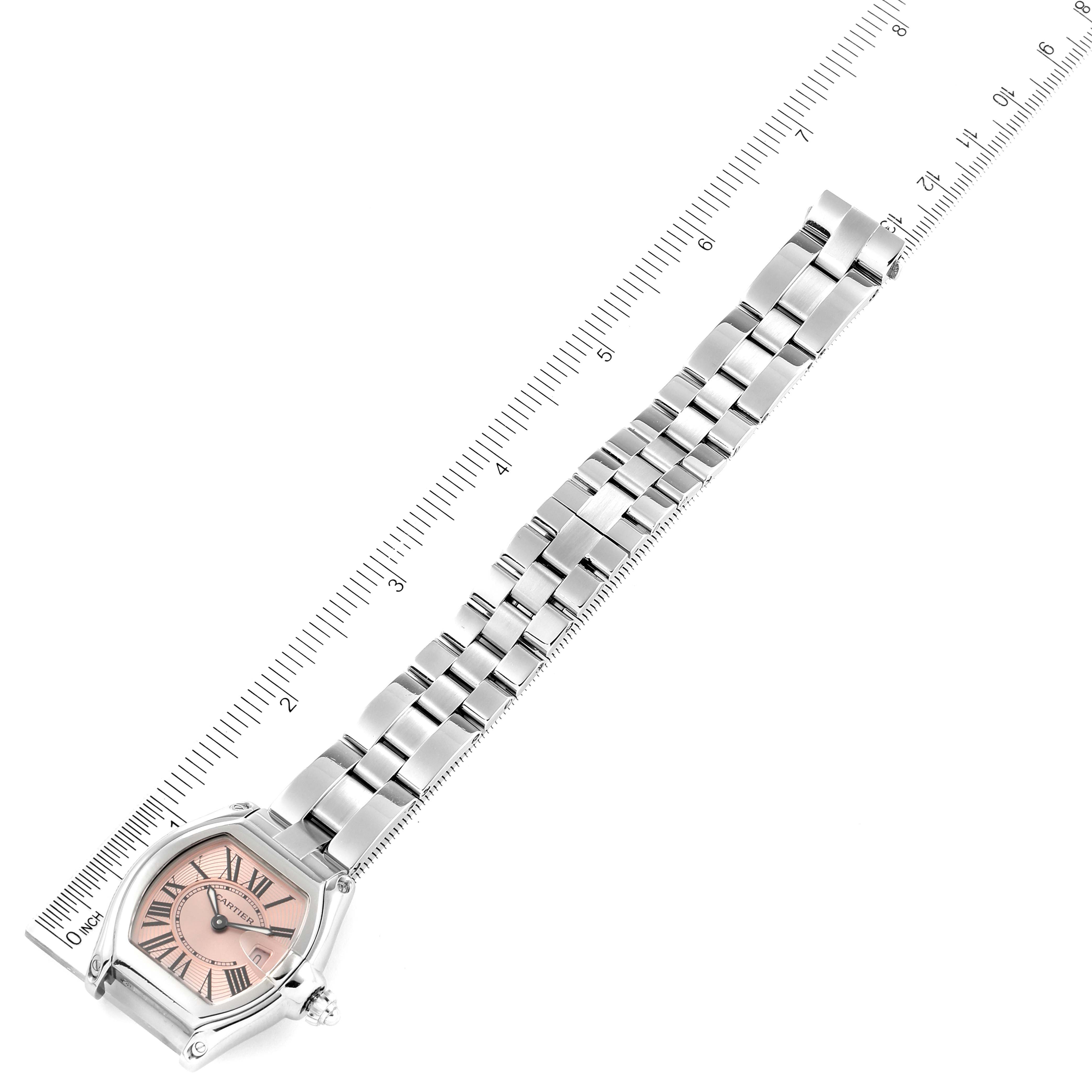 This image shows a Cartier Roadster W62017V3 Women's Stainless Steel Pink Dial W62017V3 Women's Stainless Steel Pink Dial watch angled diagonally, displaying the face and full bracelet alongside a ruler.