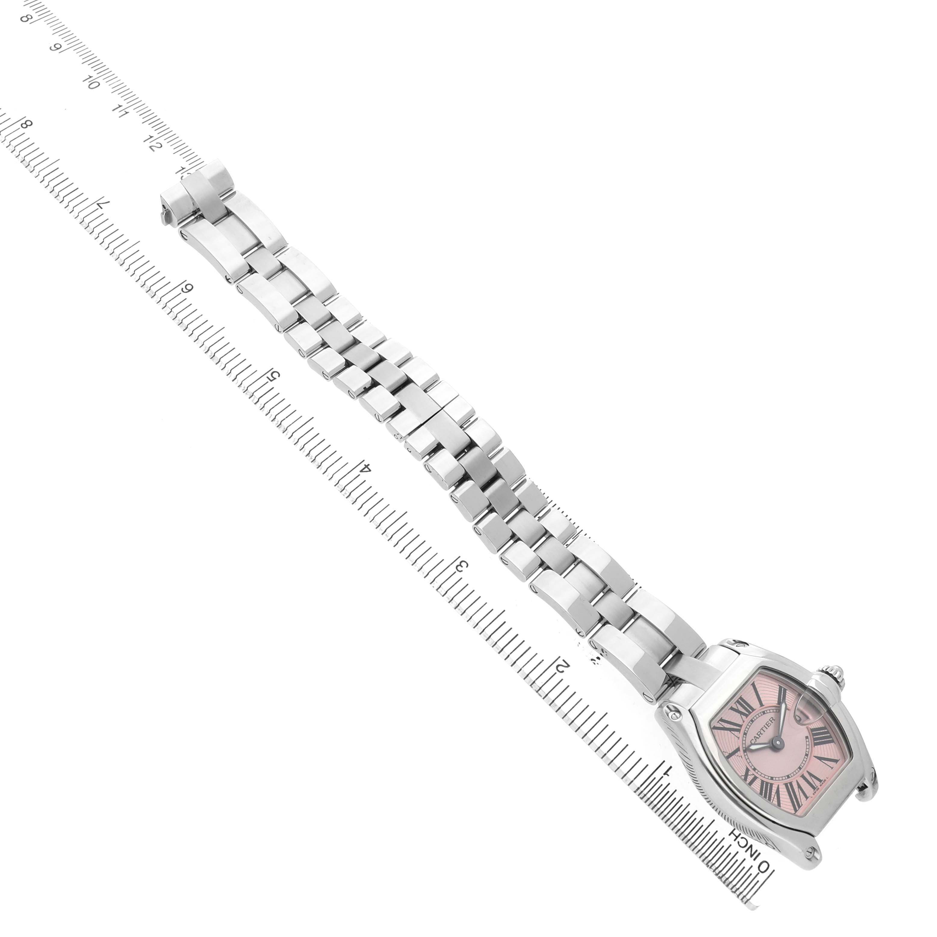 The Cartier Roadster W62017V3 Women's Stainless Steel Pink Dial watch is shown in an angled view with its full metal bracelet extended and visible alongside a ruler for scale.